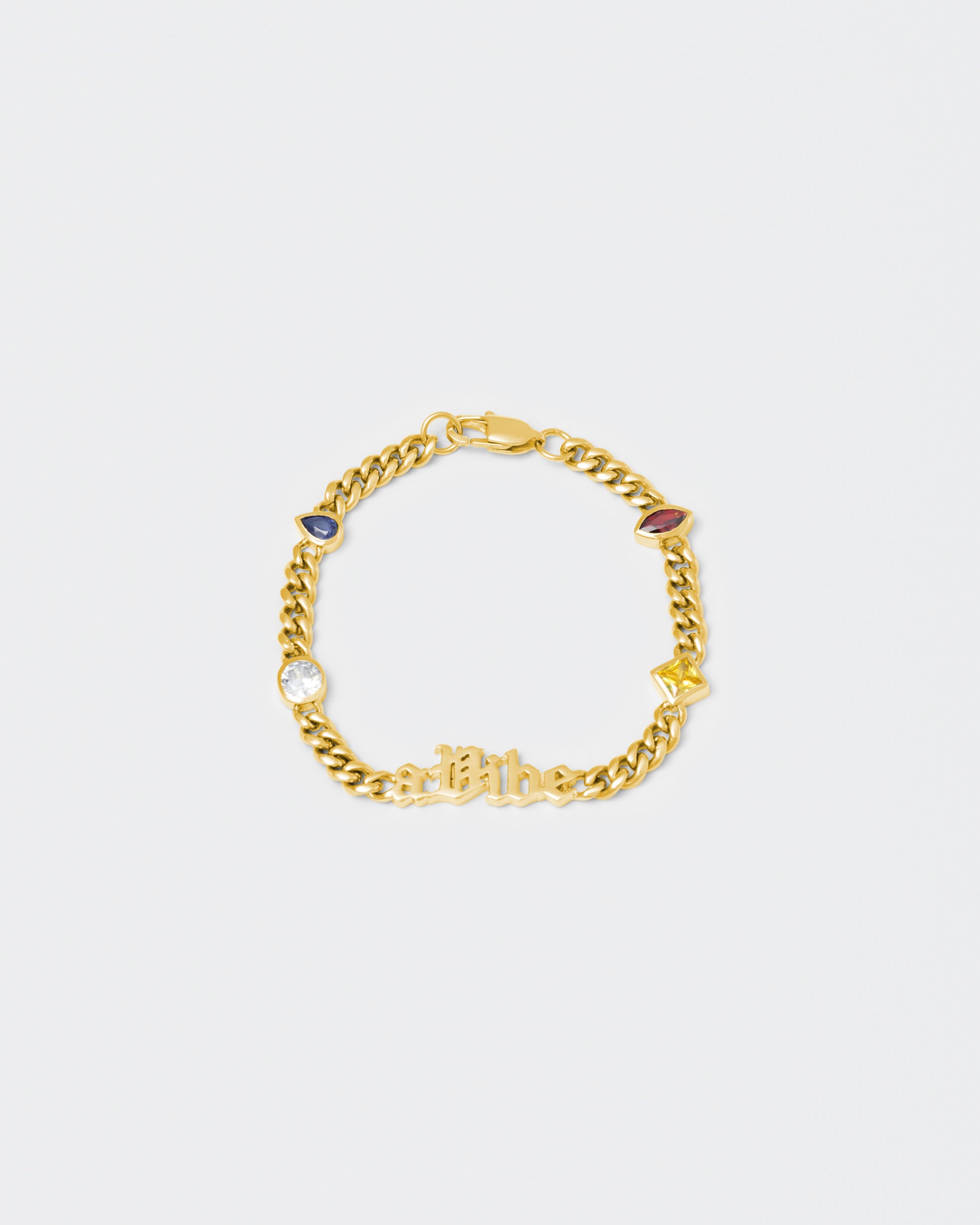 A Vibe cuban chain bracelet with 18kt yellow gold coating, mixed shape bezel stones in diamond white, yellow, garnet, tanzanite and "A Vibe" central metal tag. Lobster clasp with logo