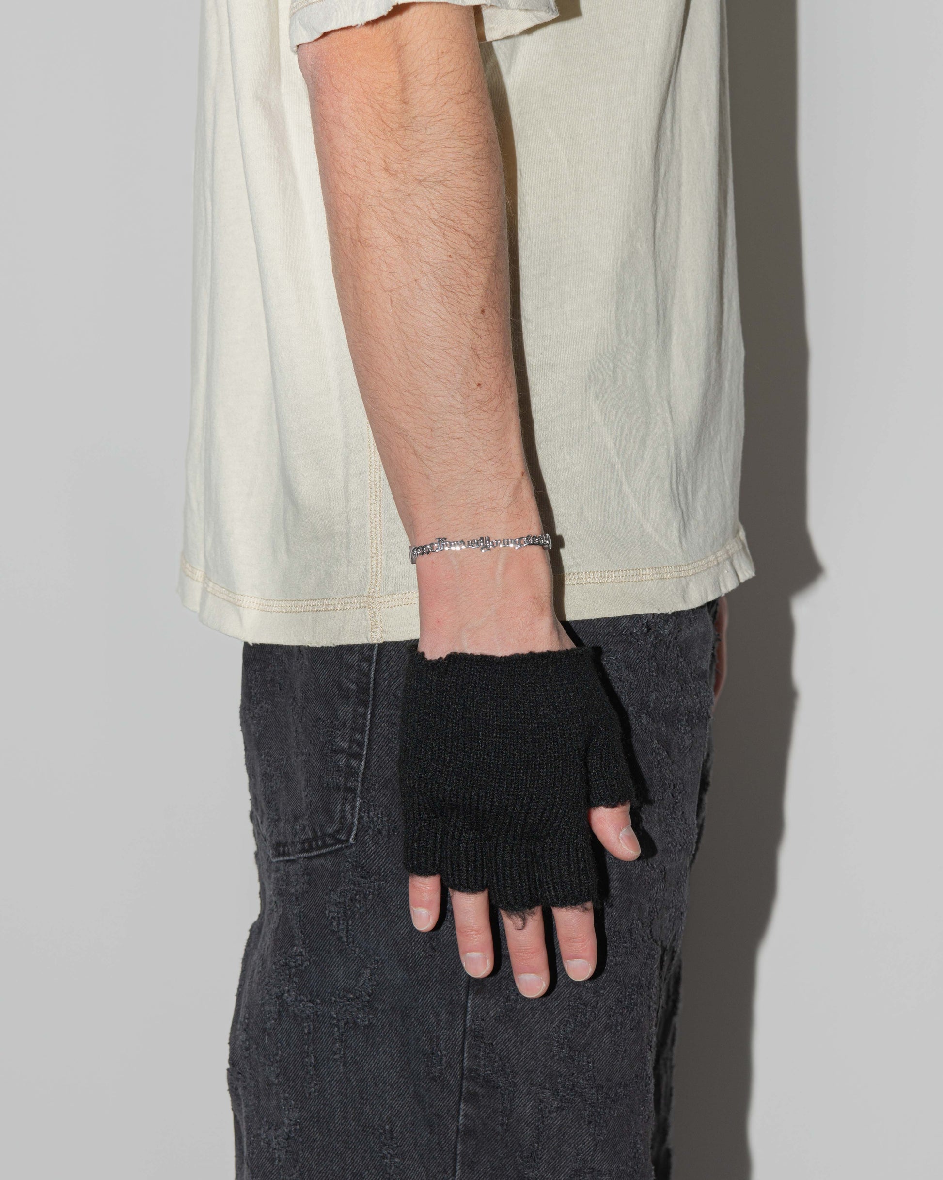 man wearing forever young cuban chain bracelet with 18kt white gold coating, mixed shape bezel stones in diamond white, burna blue, green, chocolate and "Forever Young" central metal tag