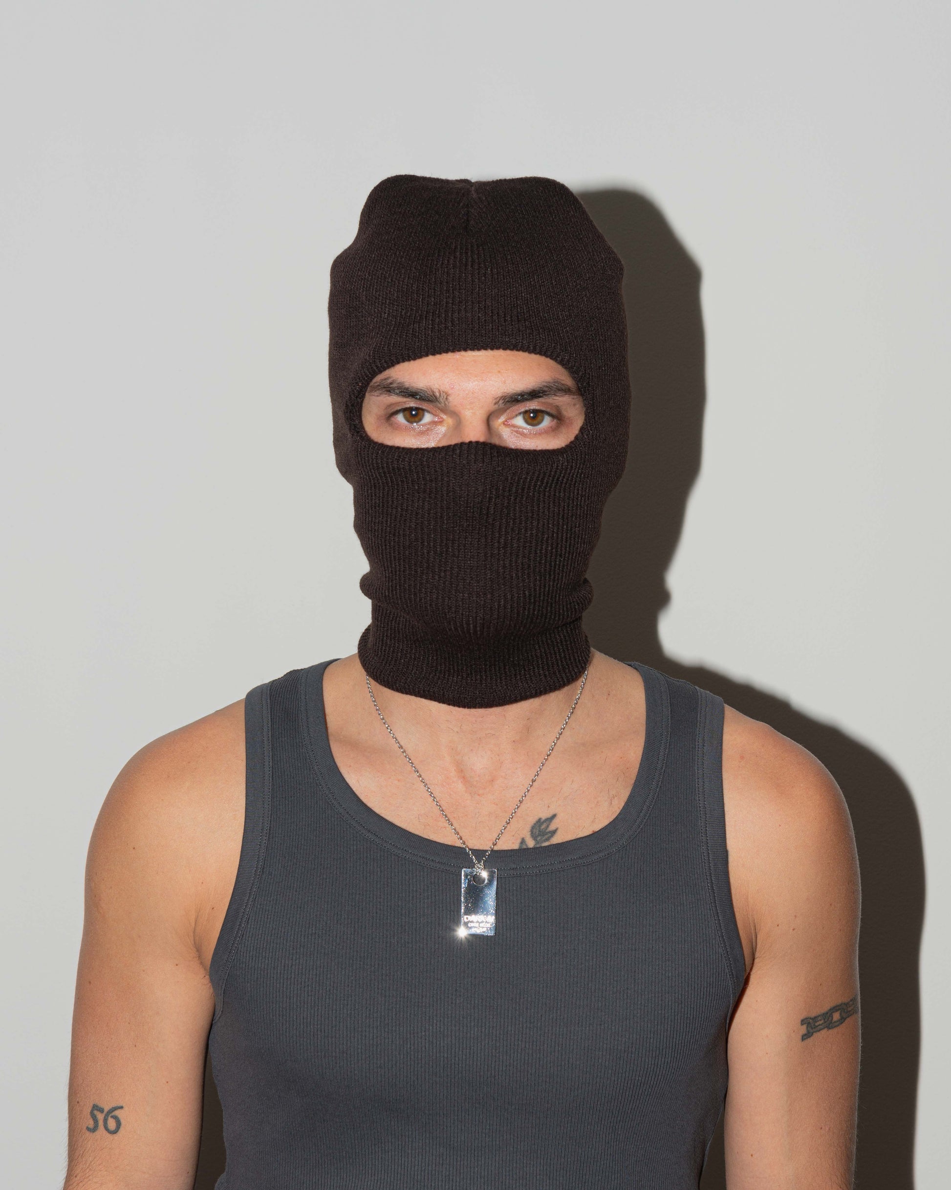 Man wearing size tag pendant necklace with 18kt white gold coating with lasered logo and details