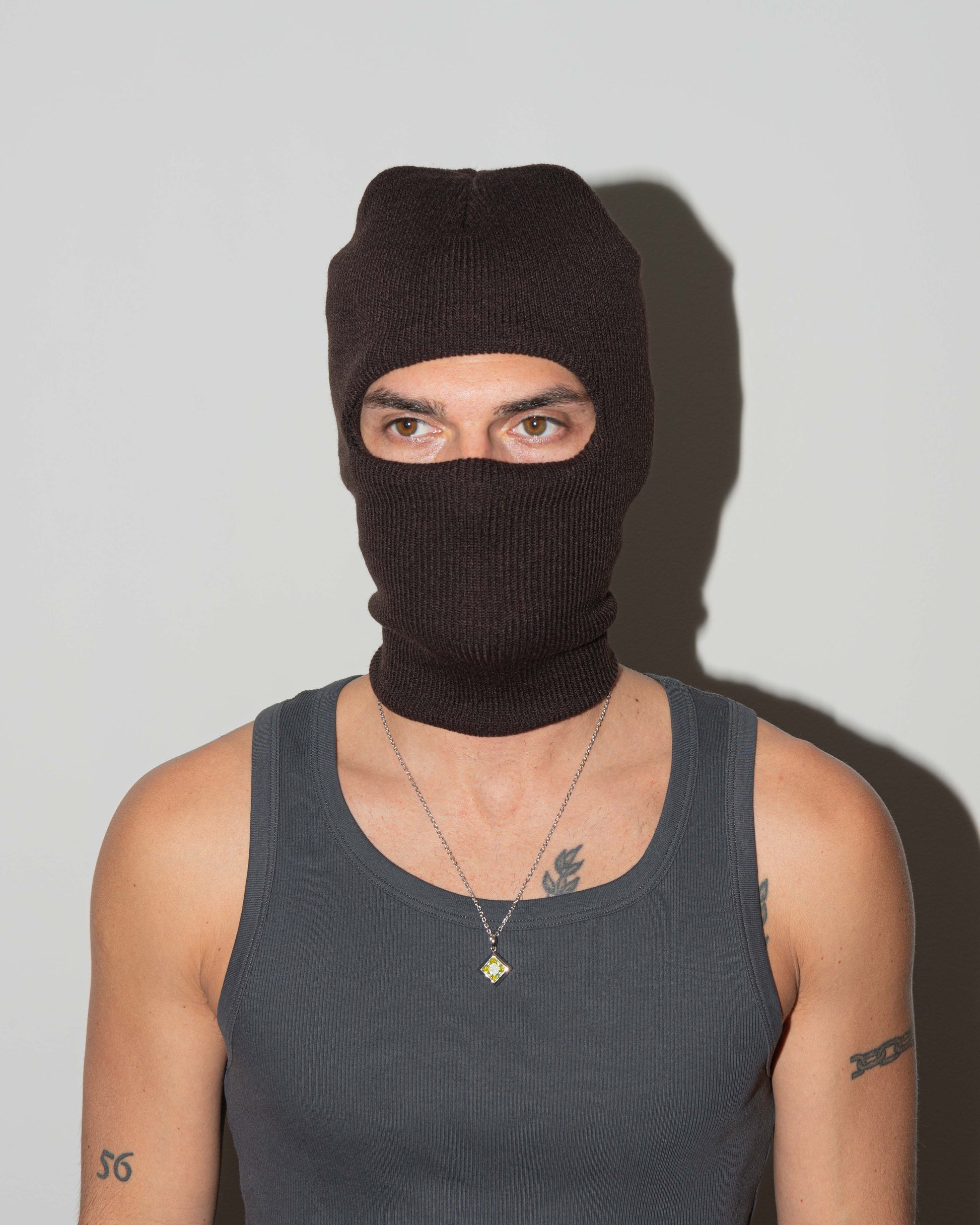 Man wearing via Savona pendant necklace with 18kt white gold coating rhombus shaped princess-cut stone in olive.