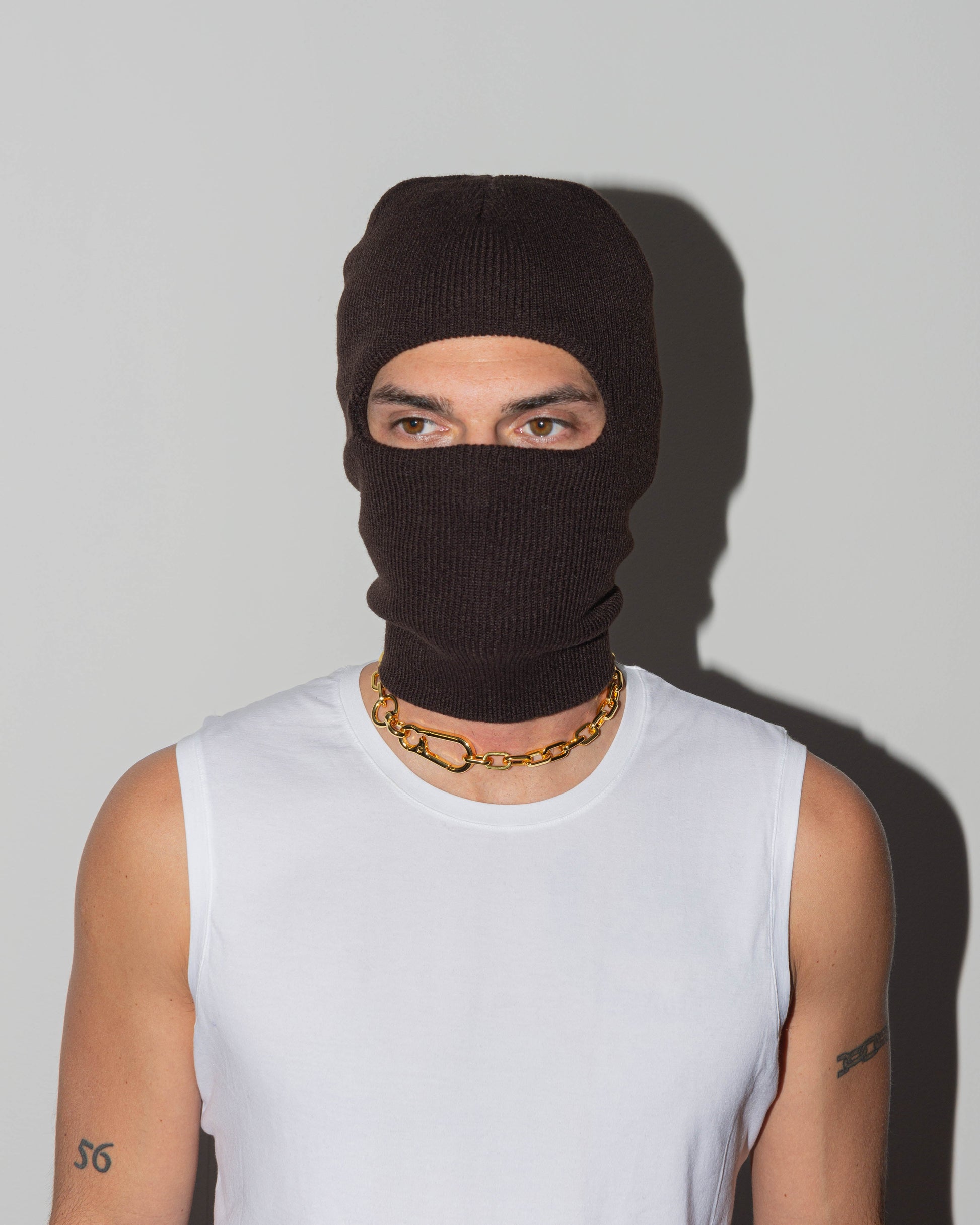 man with black suit wearing 18k yellow or white gold coated rolo chain choker with lasered logo oversize carabiner clasp.