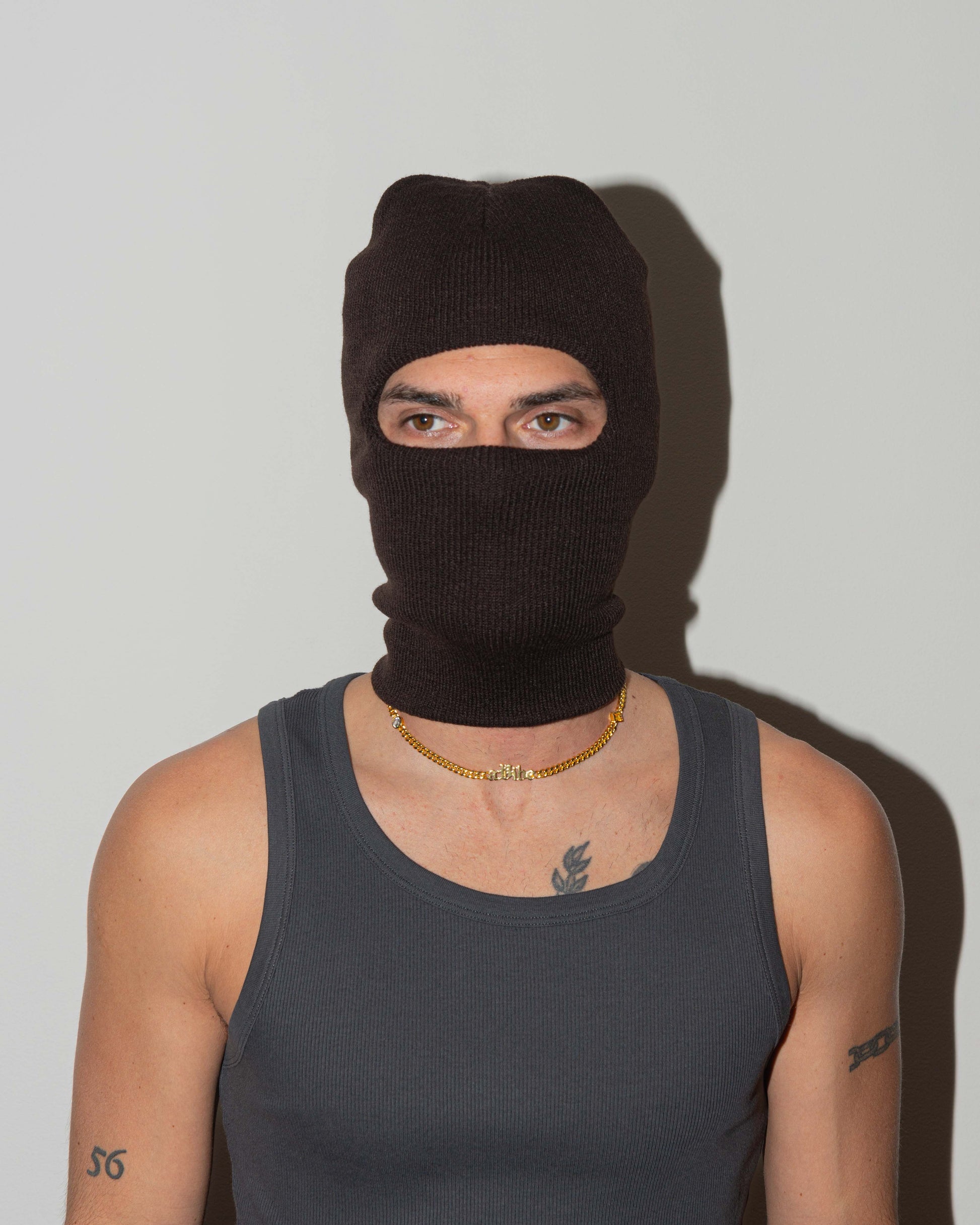 man wearing a vibe cuban chain necklace with 18kt yellow gold coating, mixed shape bezel stones in diamond white, yellow, garnet, tanzanite and "A Vibe" central metal tag