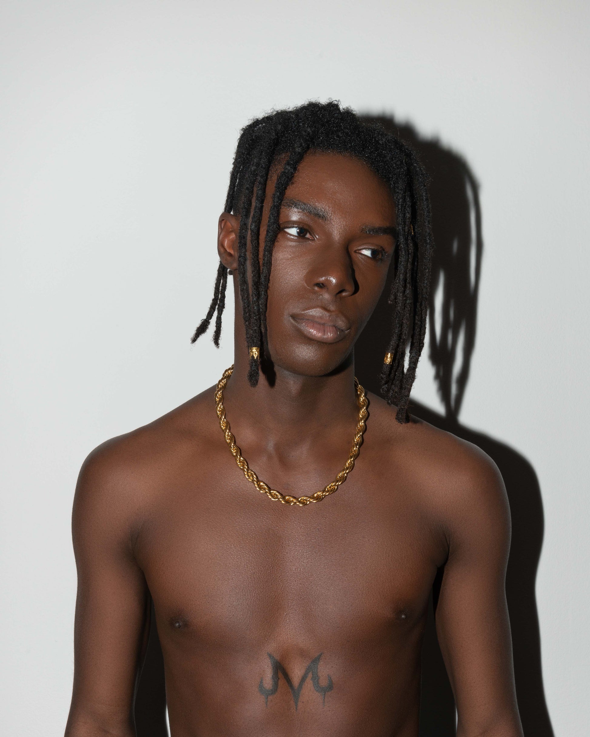 street style man wearing 18k yellow gold coated 90s-inspired rope chain necklace with lasered logo regular lobster clasp.