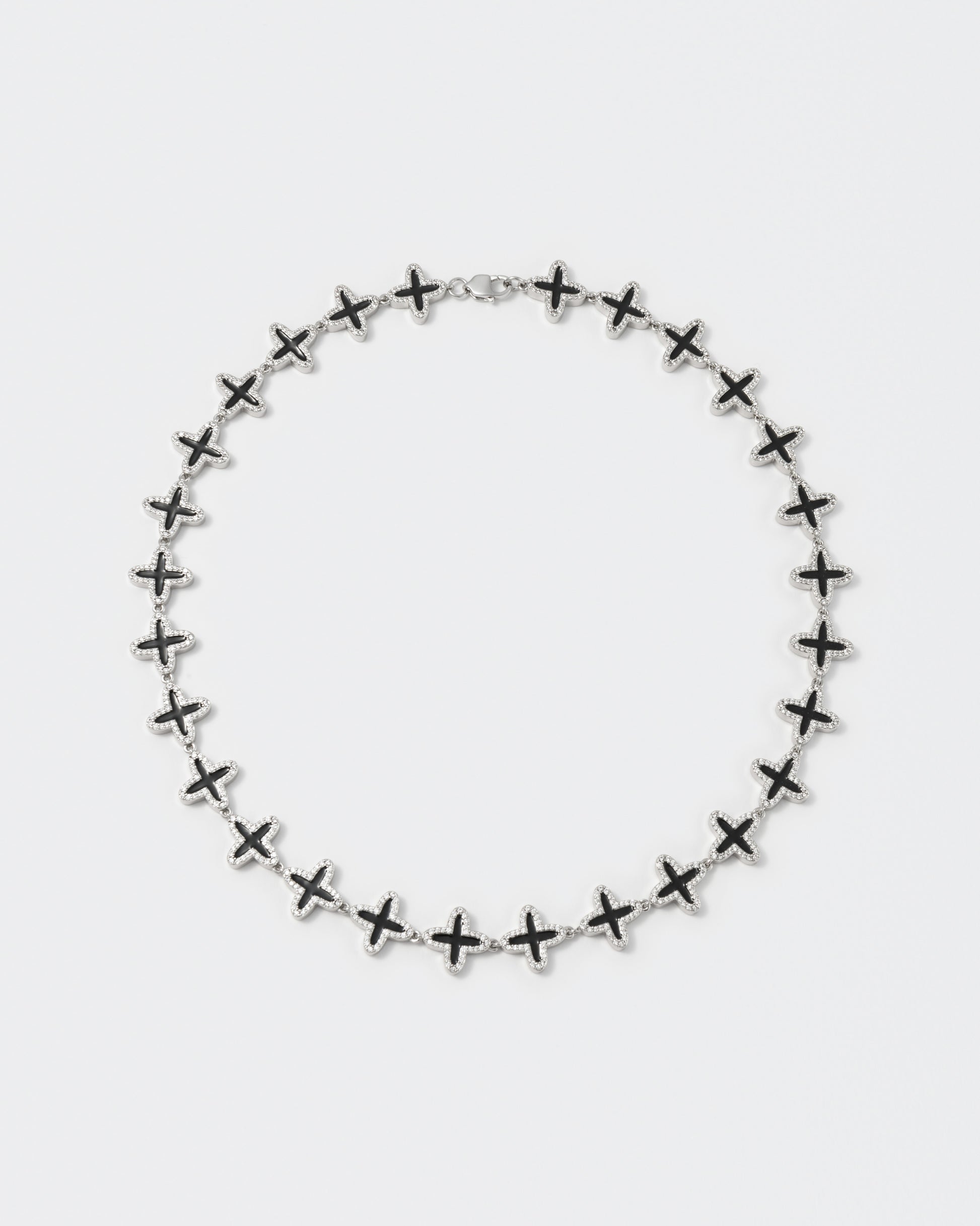 Clover tennis chain necklace with 18kt white gold coating and hand-set stones in diamond white. Finished with hand painted black enamel and lobster clasp with logo