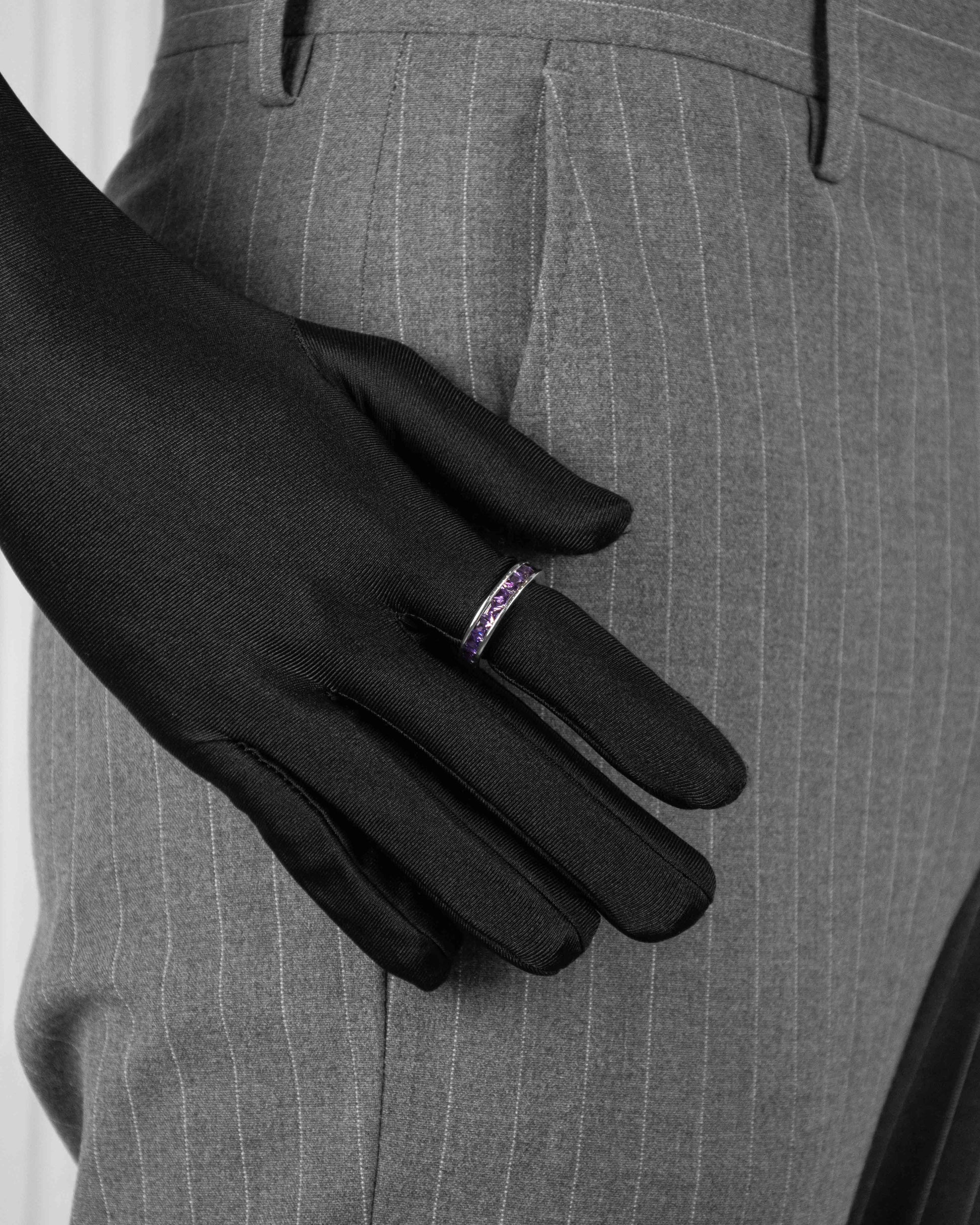 man with black suit wearing ring with purple stones