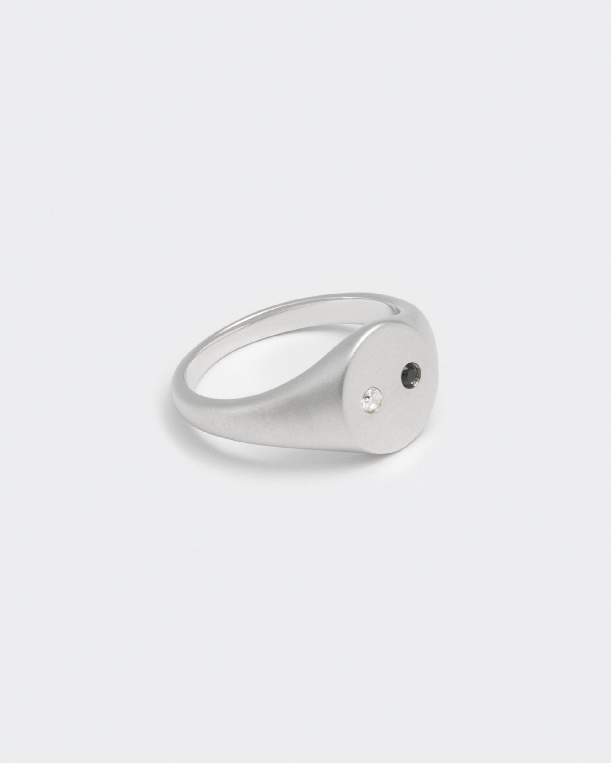 detail of white gold satined ring with hand-set stones in white and black for man and women