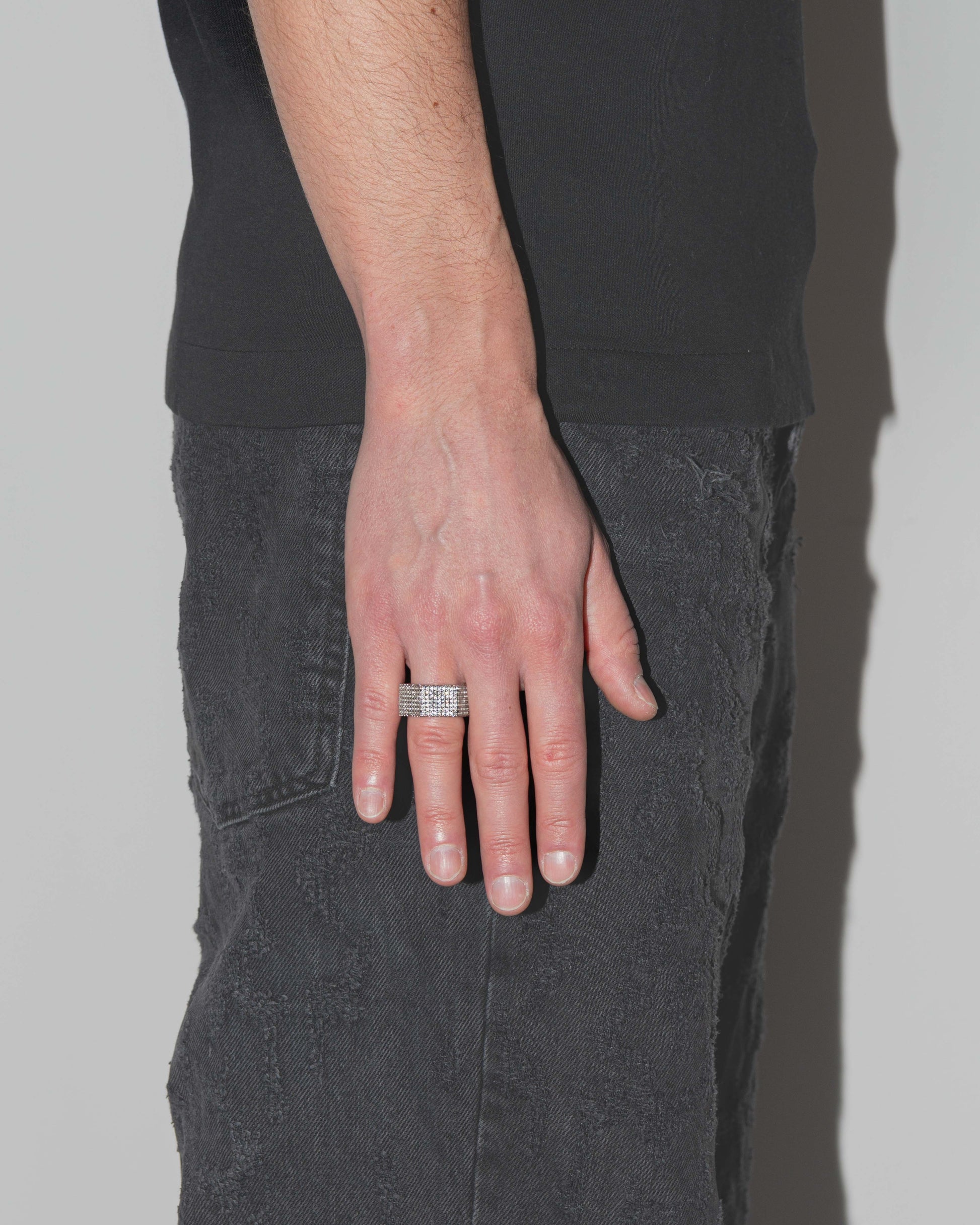 man wearing bolt ring with 18kt white gold coating and 360° degrees hand-set micropavé stones in diamond white with highly polished inner ring and logo engraved