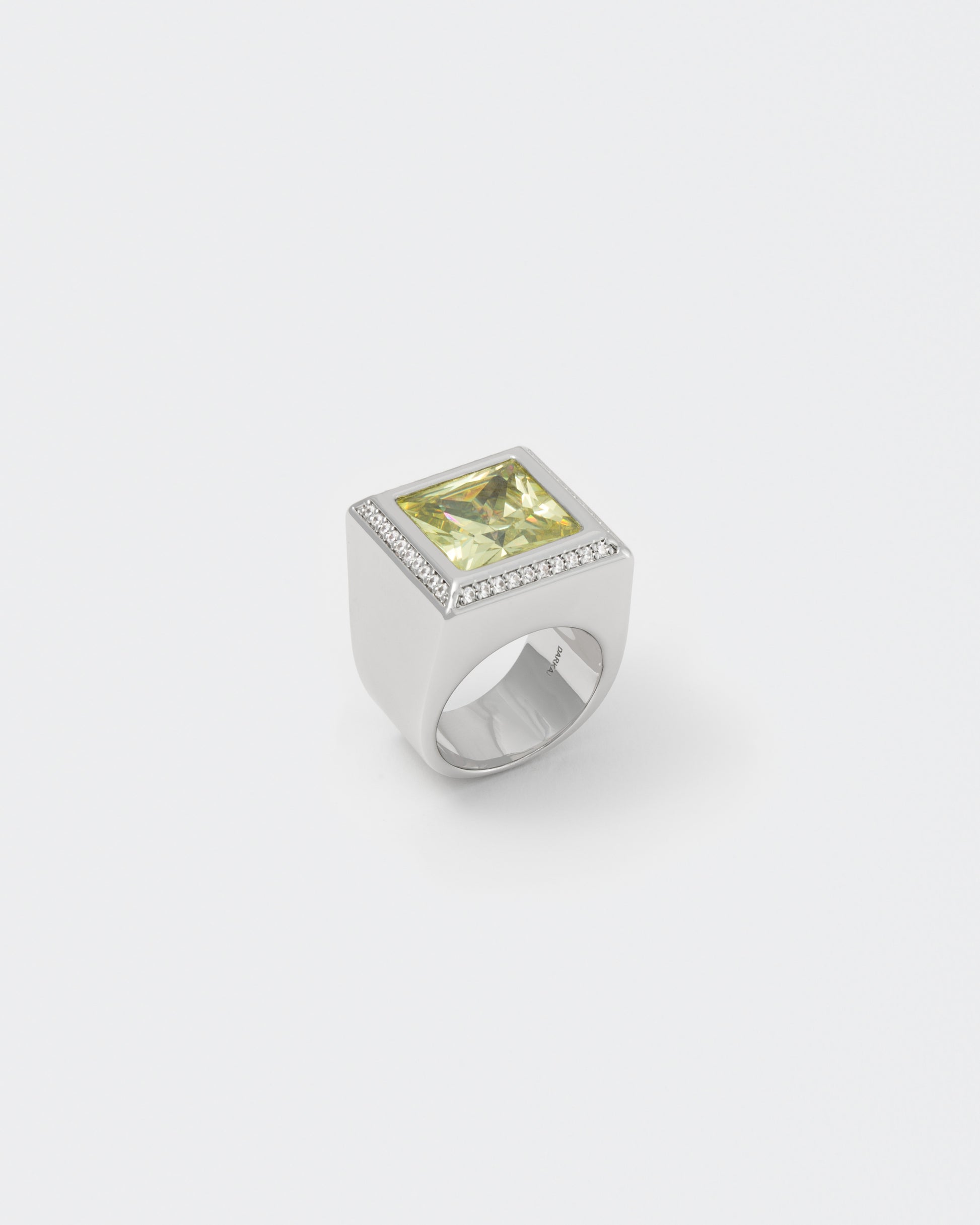 Championship ring with 18kt white gold coating, oversize princess-cut stone in olive with hand-set diamond white zircons on the frame. Highly polished structure and logo engraved