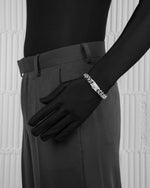 man with black suit wearing white cuban bracelet