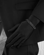 man with black suit wearing black cuban bracelet with black stones