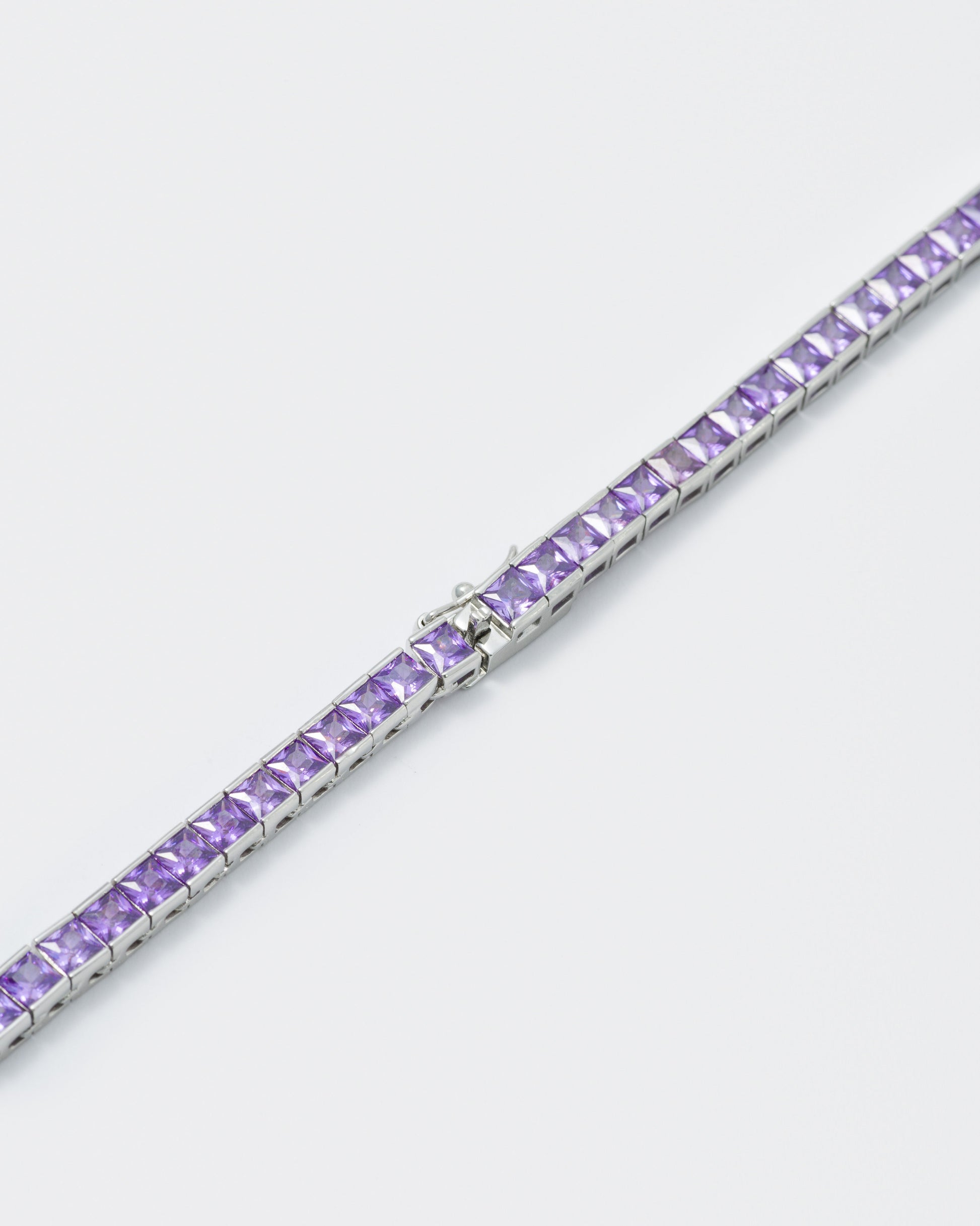 detail of 18k white gold coated tennis chain bracelet with hand-set princess-cut amethyst stones