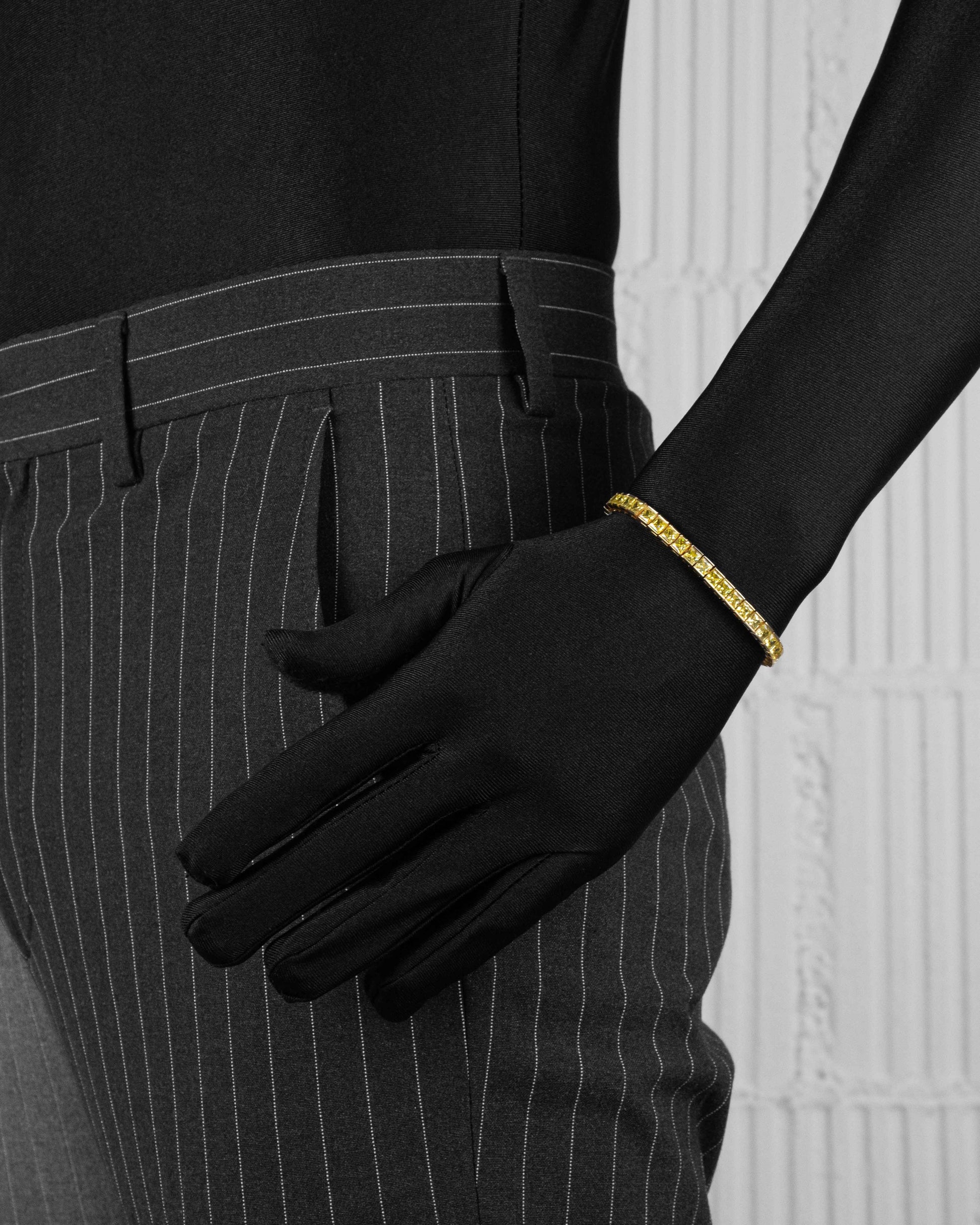 man with black suite wearing yellow tennis bracelet with yellow hand-set princess-cut stones