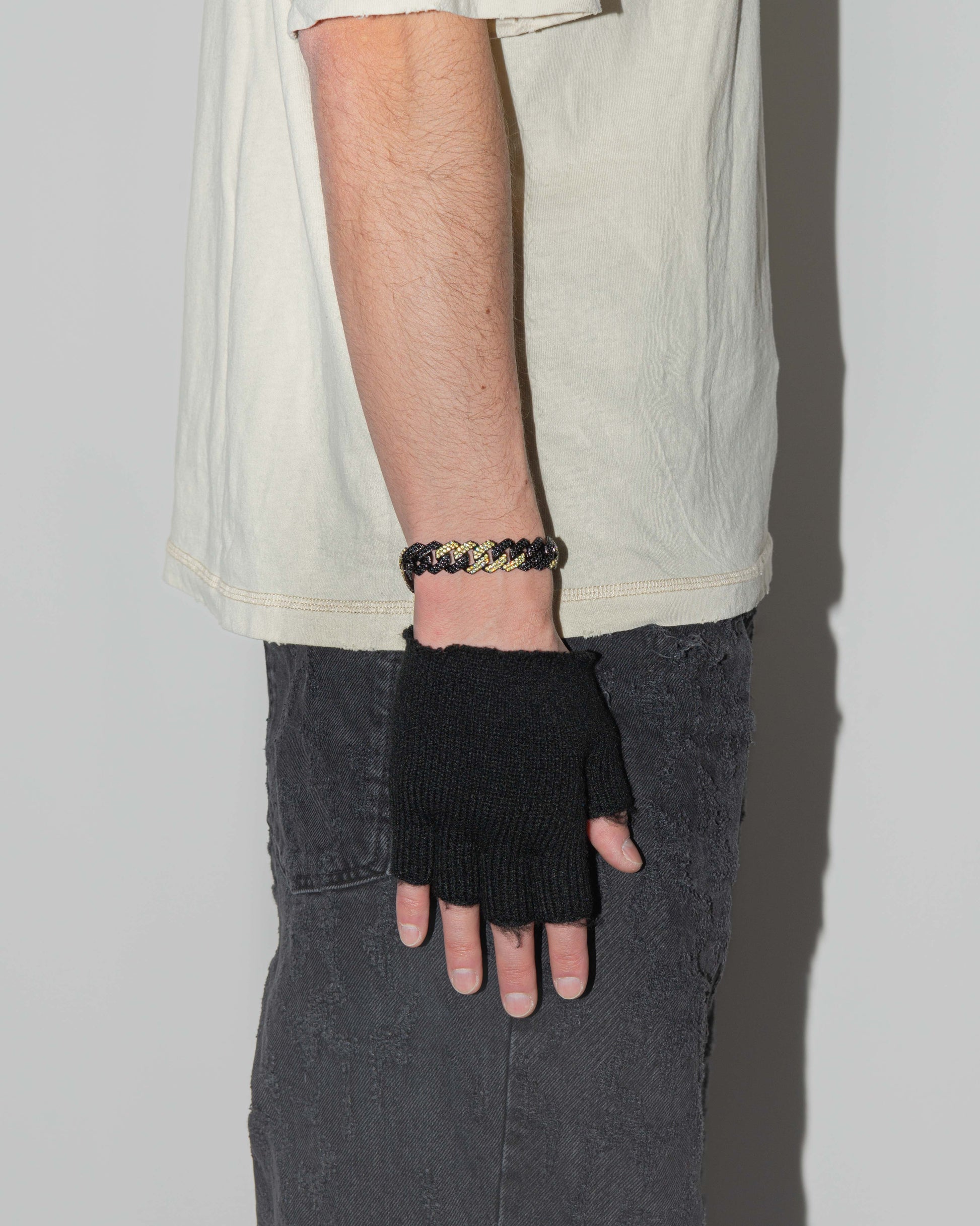 man wearing danger prong chain bracelet with deep black PVD coating and hand-set micropavé stones in black and lemon yellow