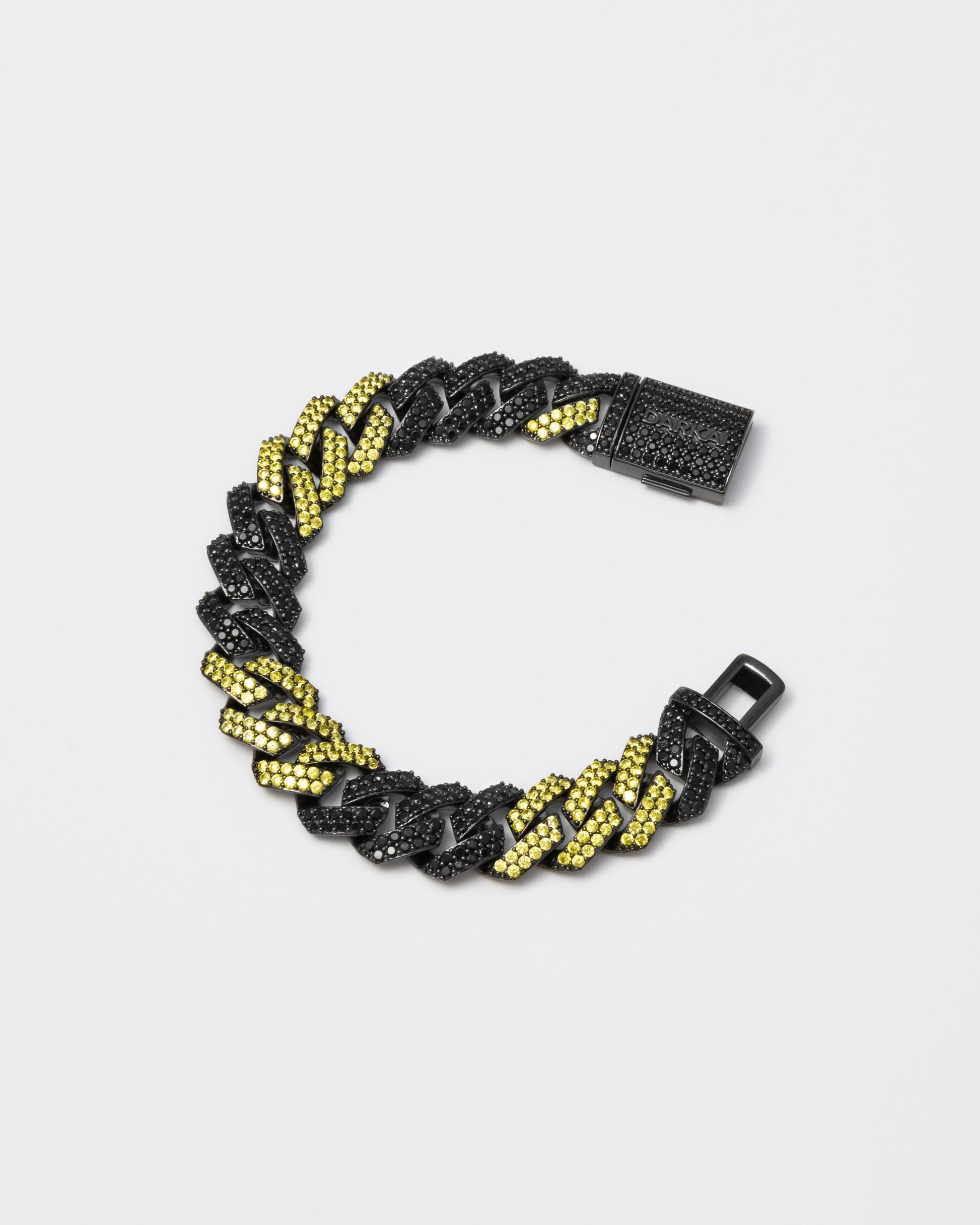 Prong chain bracelet with deep black PVD coating and hand-set micropavé stones in black and golden yellow. Fine jewelry grade drawer closure with logo