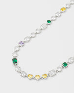 detail of mixed bezels chain bracelet with 18kt white gold coating and hand-set stones of irregular shapes and colors. Ensemble of rectangular, square, round and heart-shaped stones in diamond white, amethyst, lilac, emerald green and gold yellow. Invisible closure with logo
