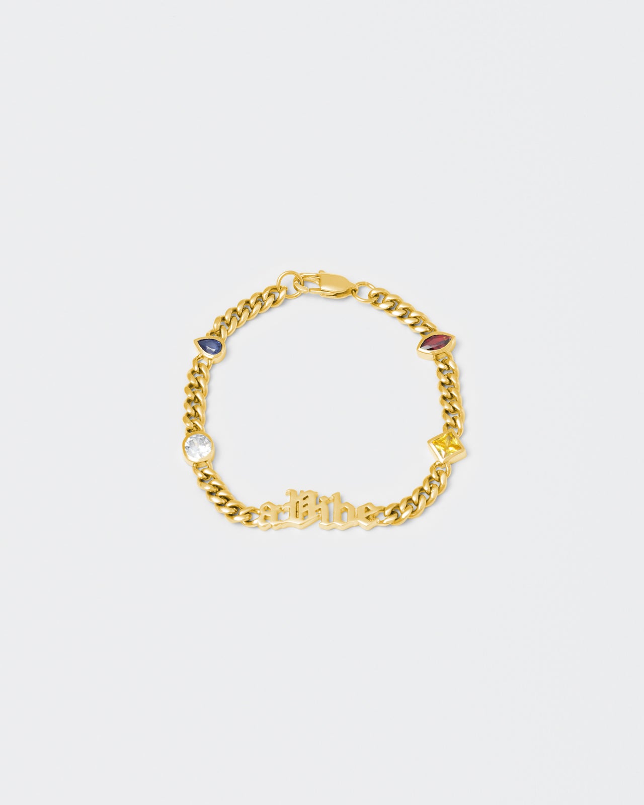 A Vibe cuban chain bracelet with 18kt yellow gold coating, mixed shape bezel stones in diamond white, yellow, garnet, tanzanite and "A Vibe" central metal tag. Lobster clasp with logo