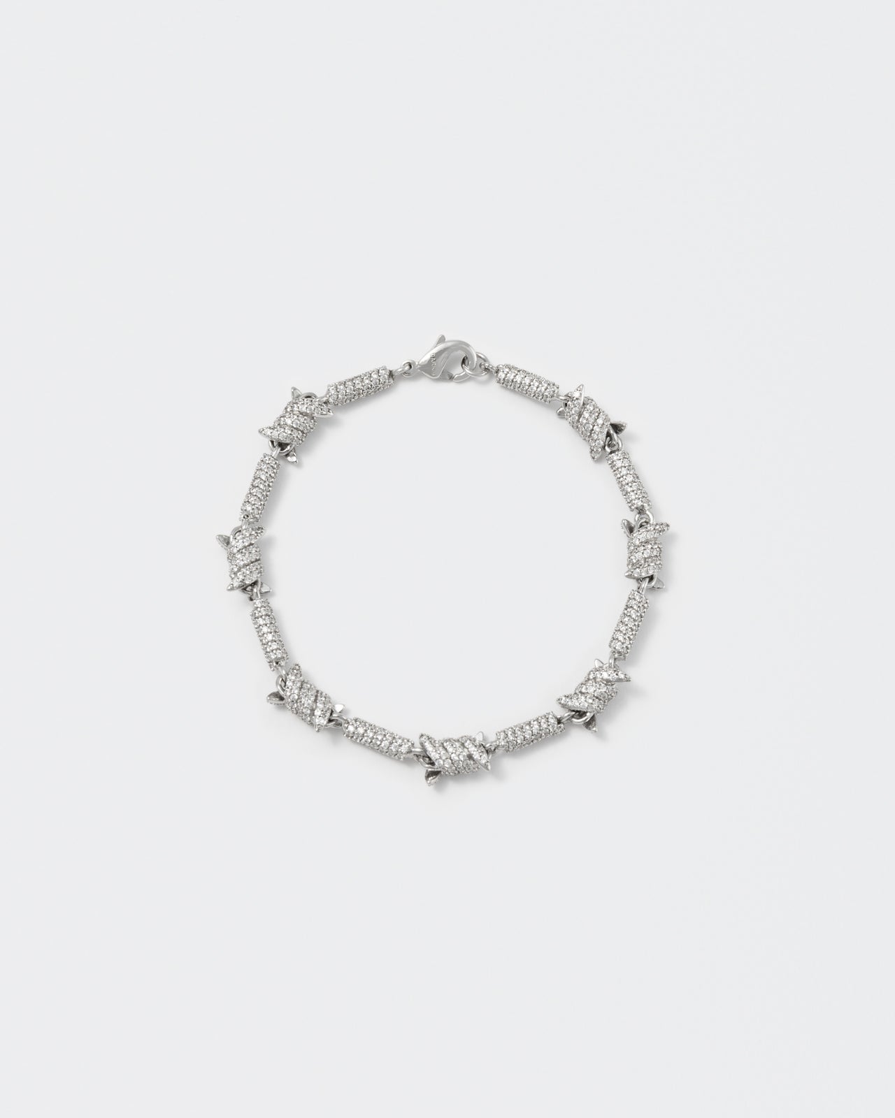 Barbed Wire bracelet with 18kt white gold coating and hand-set micropavé stones in diamond white. Lobster clasp closure with logo