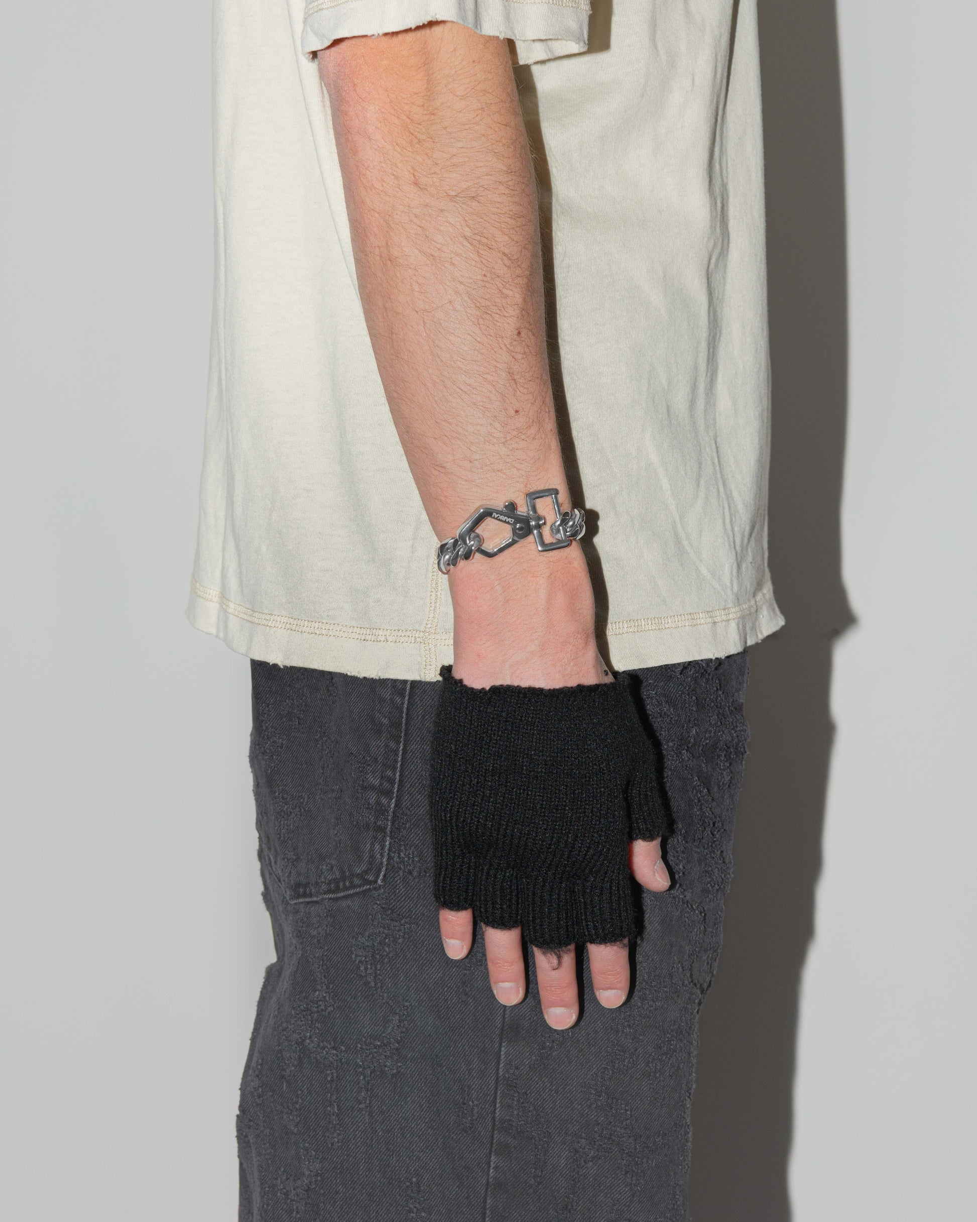 man wearing cutting edge cuban chain bracelet with 18kt white gold coating and oversize carabiner clasp with engraved logo.