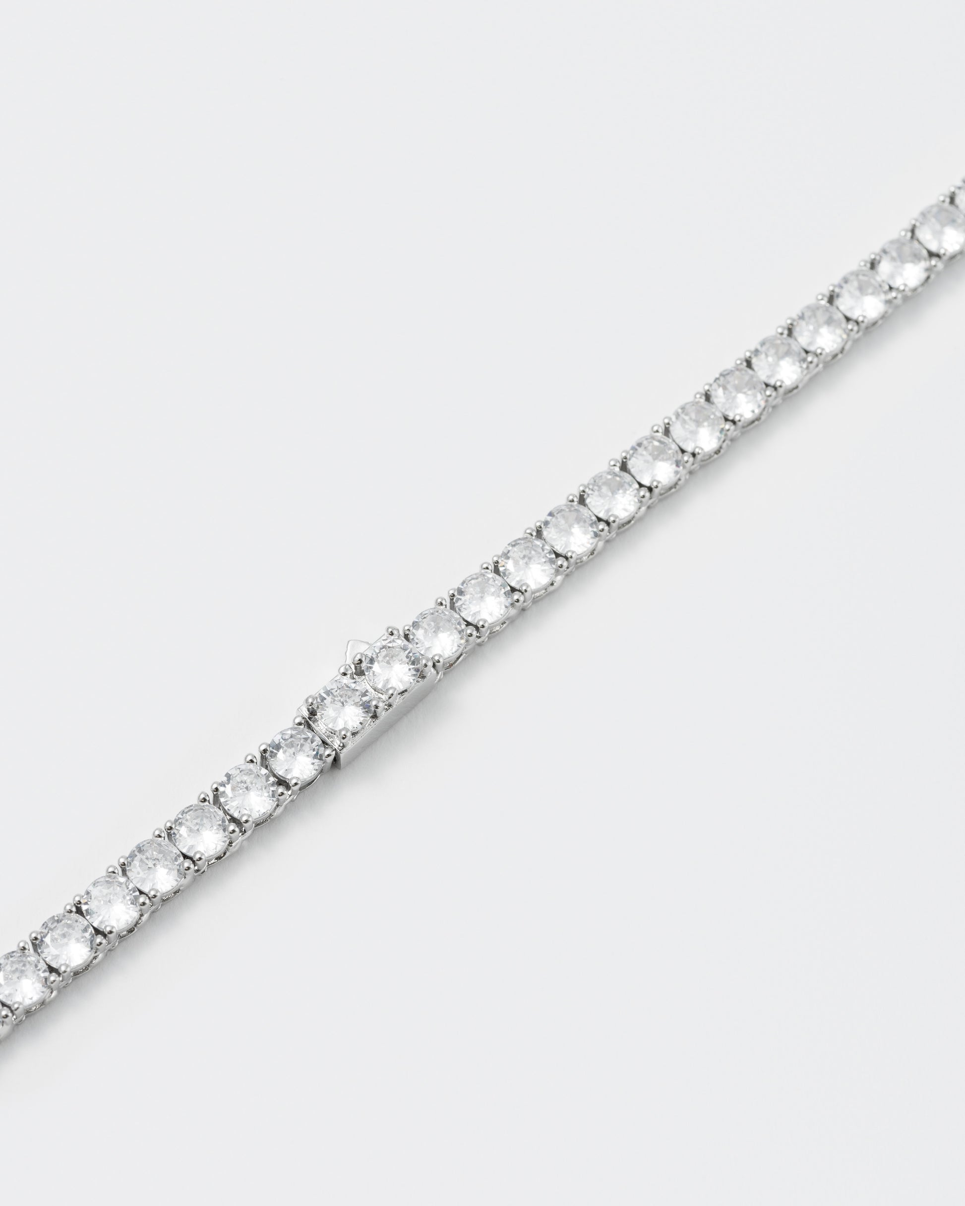 detail of tennis bracelet with 18kt white gold coating and hand-set round brilliant-cut stones in diamond white