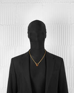 man with black suit wearing 18k yellow gold coated heart pendant necklace with black and red-yellow hand painted enamels