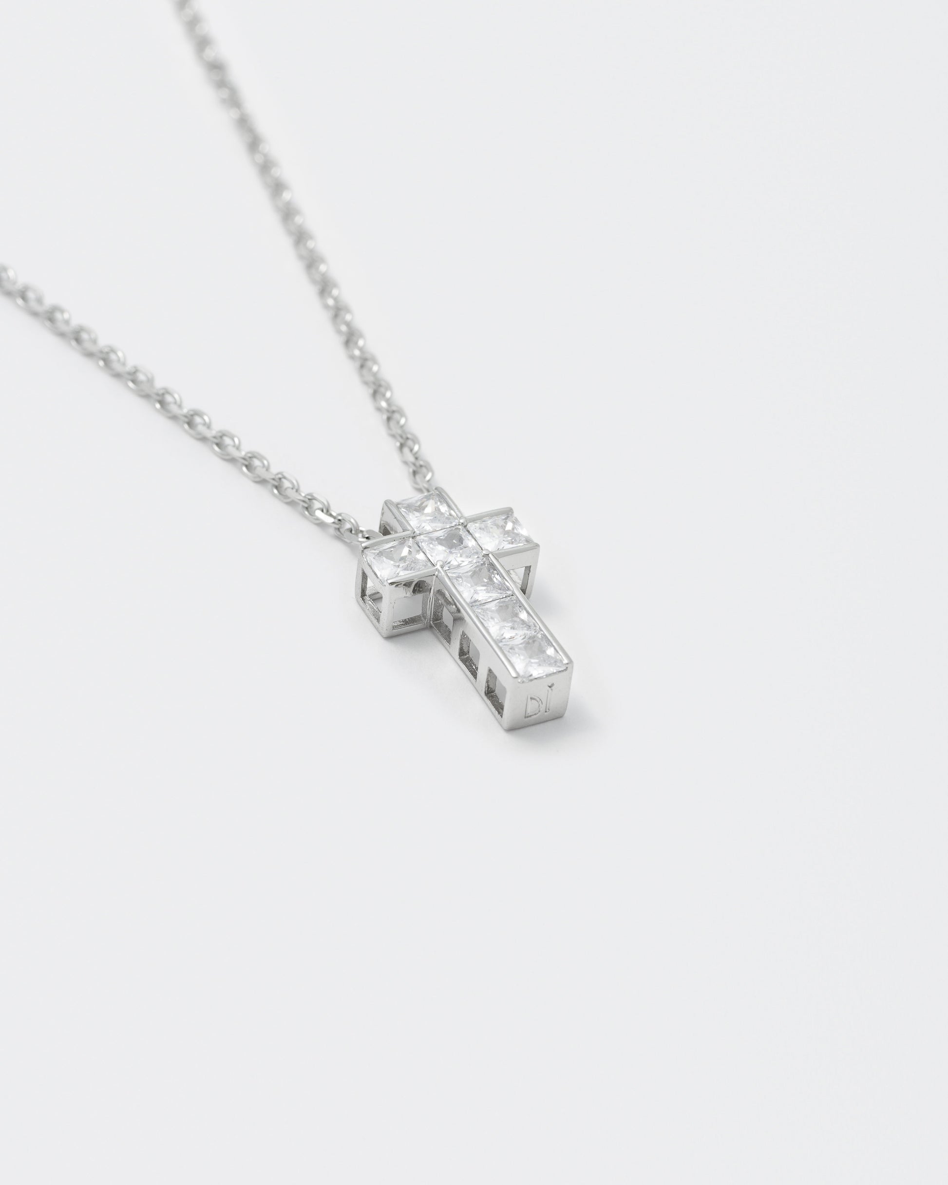 detail of 18k white gold coated cross pendant necklace with hand-set princess-cut stones in white and 3mm box chain