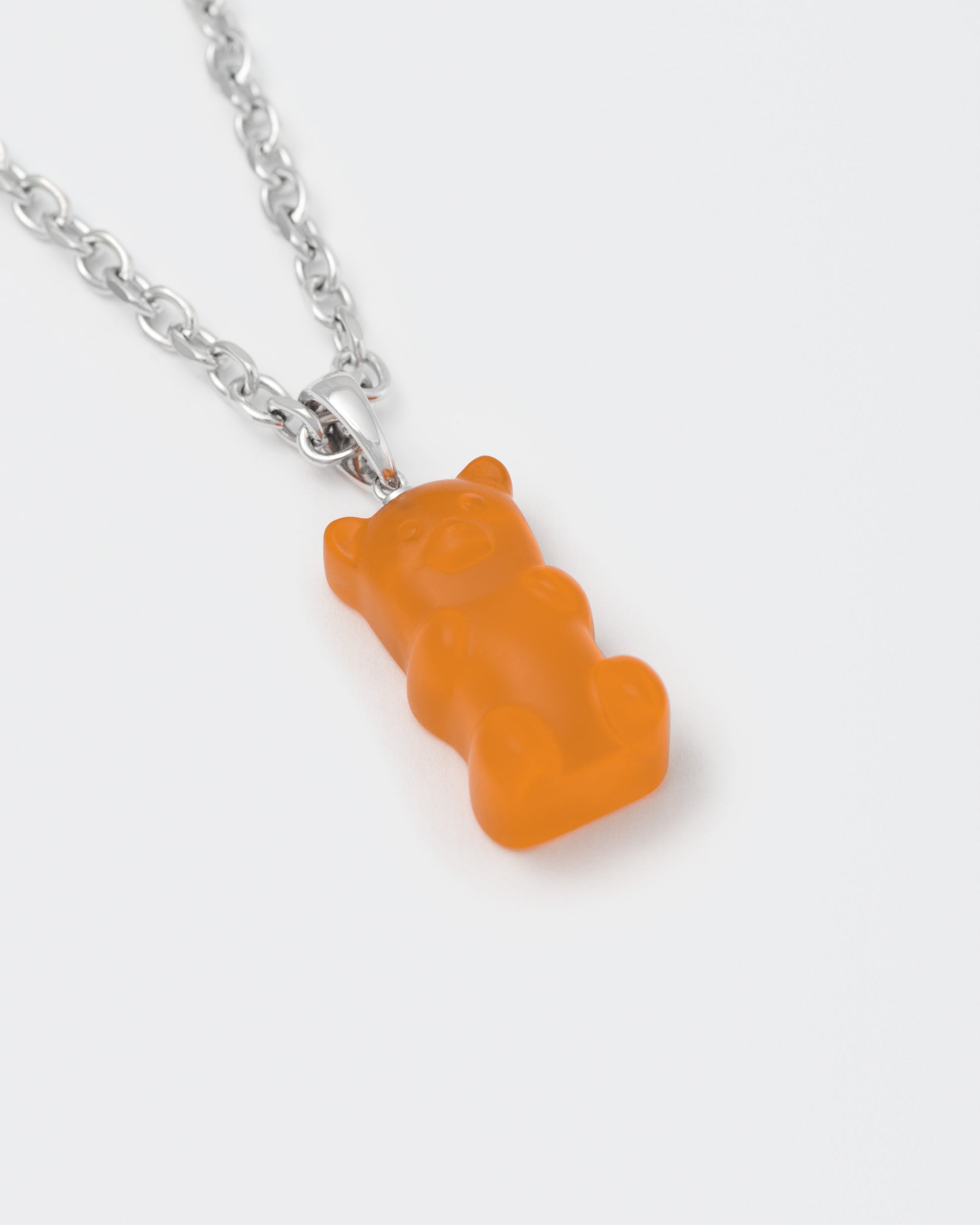 detail of 18k white gold coated gummy bear pendant necklace with 3D cut sandblasted crystal in orange and 3mm rolo chain