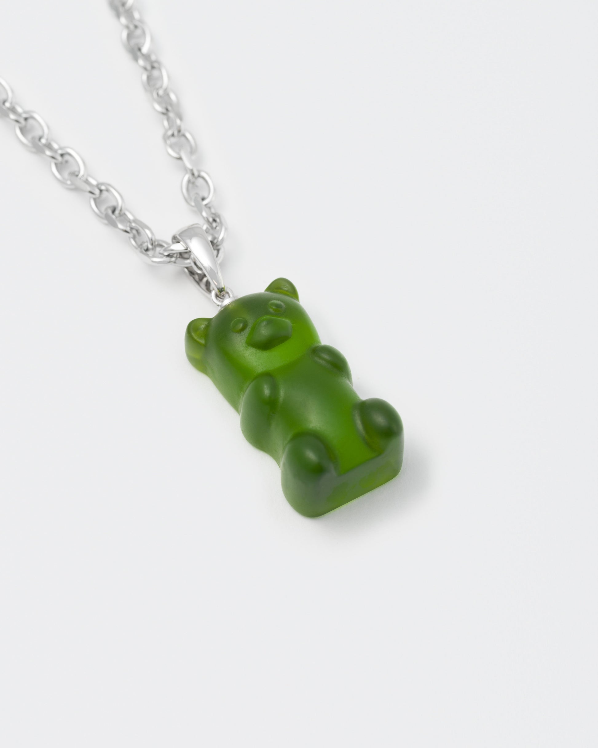 detail of 8k white gold coated gummy bear pendant necklace with 3D cut sandblasted crystal in green and 3mm rolo chain