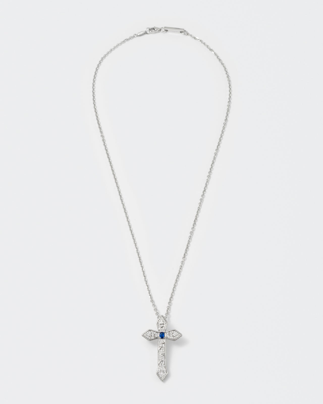 gothic cross pendant necklace with 18kt white gold coating, drop and oval shaped stones in diamond white and sapphire blue with metal gothic detailing. Hand-set micropavé on front and sides