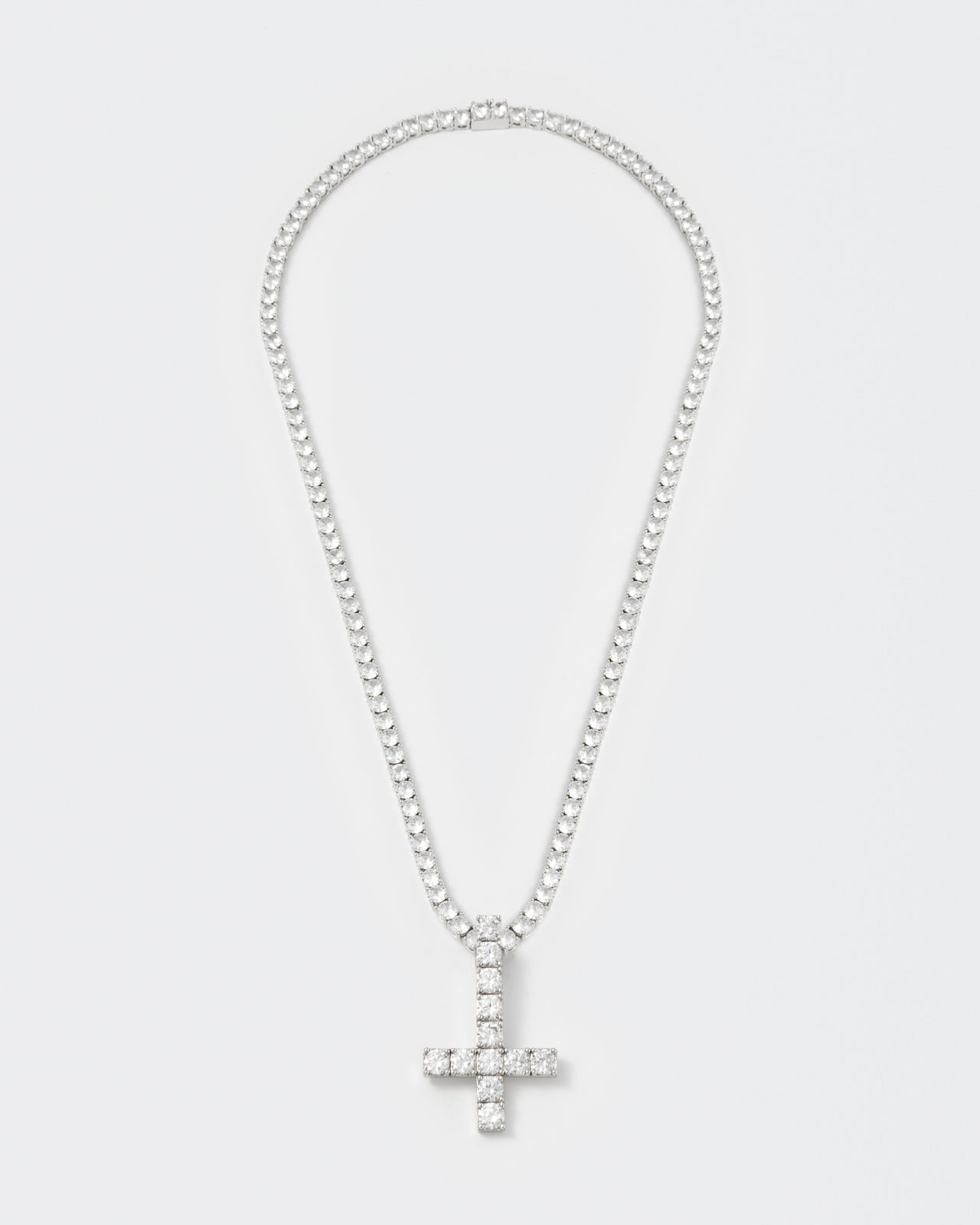 detail of 18k white gold coated reversed cross pendant necklace with hand-set stones in white and tennis chain