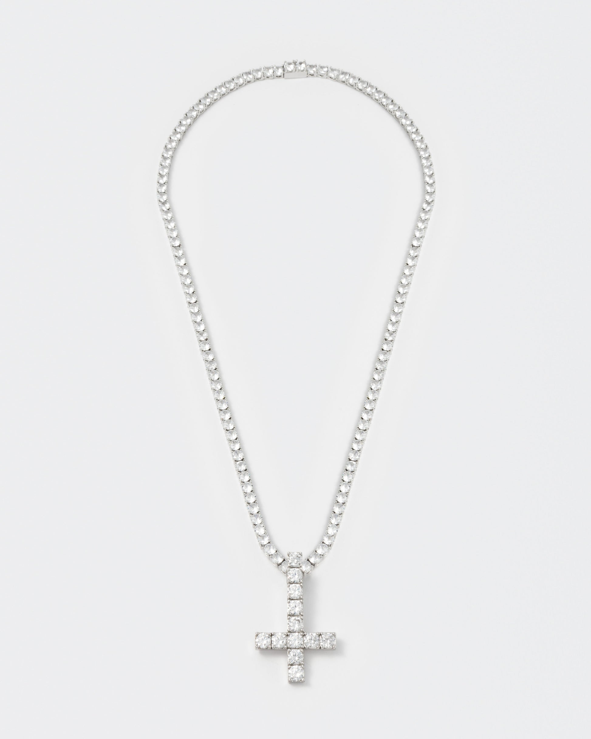 detail of 18k white gold coated reversed cross pendant necklace with hand-set stones in white and tennis chain