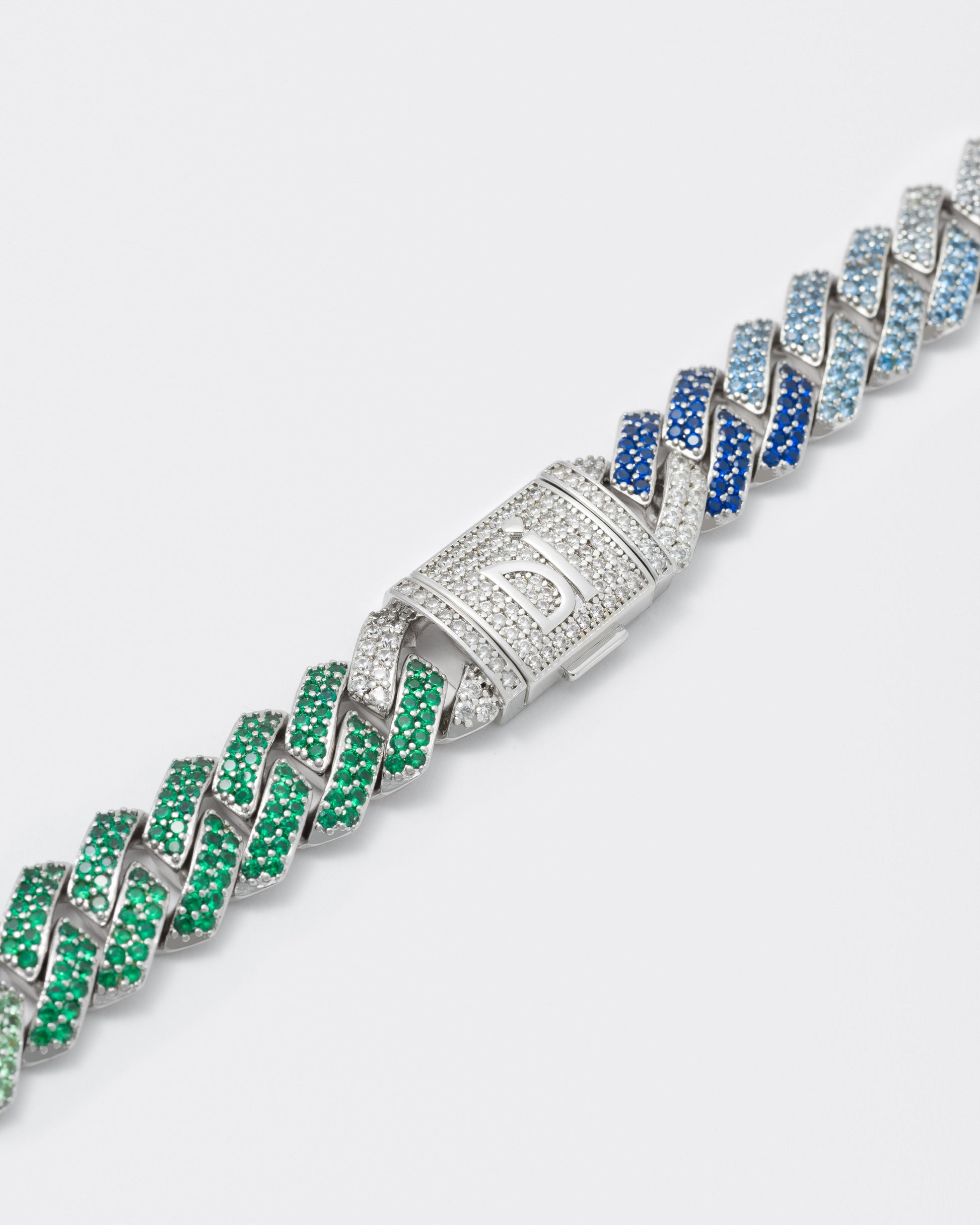 detail of 18k white gold coated prong chain necklace with hand-set micropavé stones in gradient white, brazil green, green, aquamarine, tanzanite and sapphire blue