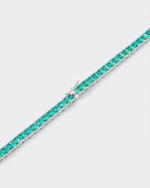 detail of 18k white gold coated tennis chain necklace with hand-set princess-cut paraiba stones