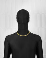 man with black suit wearing 18k gold coated tennis chain necklace with hand-set princess-cut stones in yellow