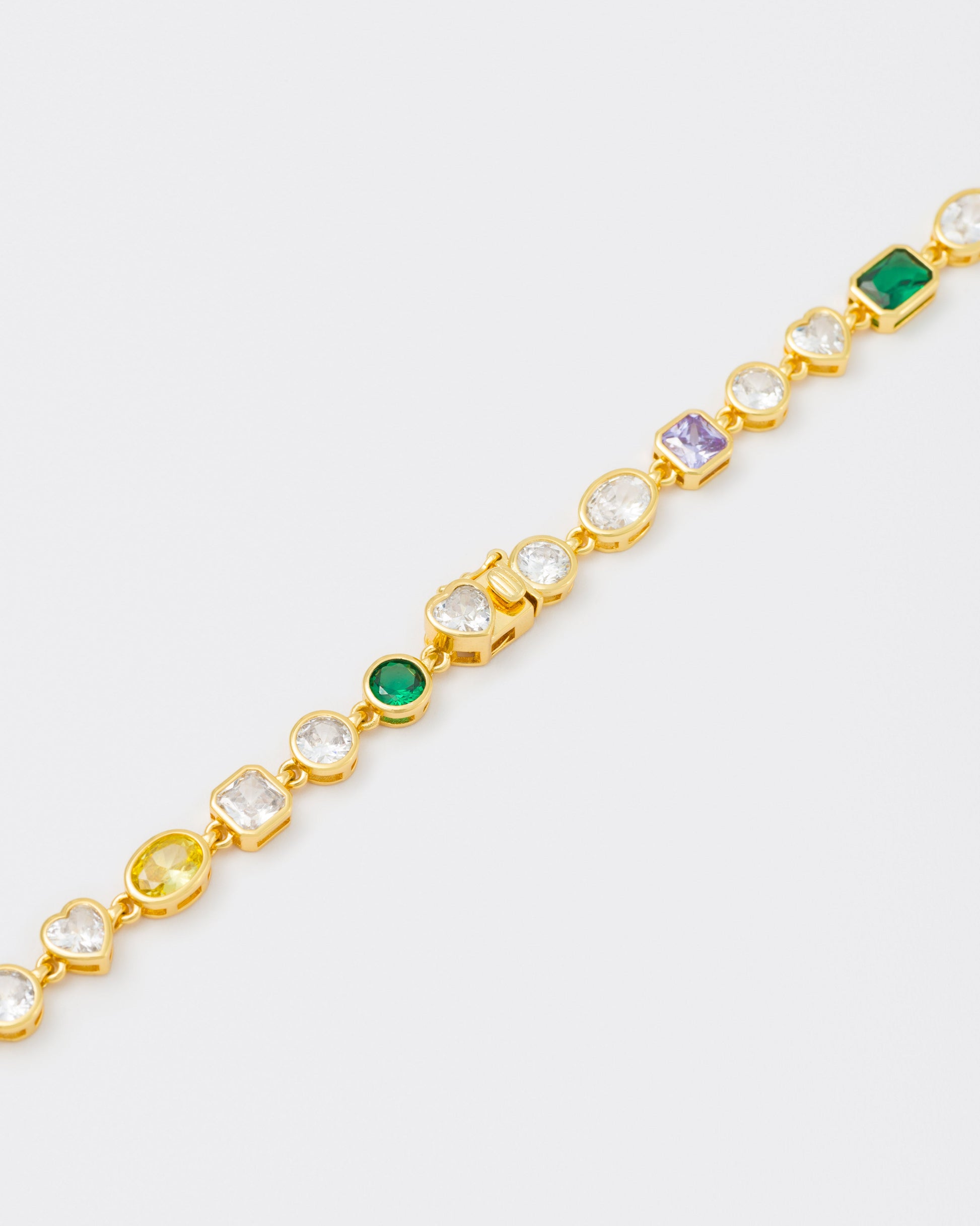 detail of clasps of 18k yellow gold coated mixed bezels chain necklace with hand-set stones in different shapes and colors. Mix of rectangular, square, round and heart-shaped stones in white, amethyst, emerald green and gold yellow