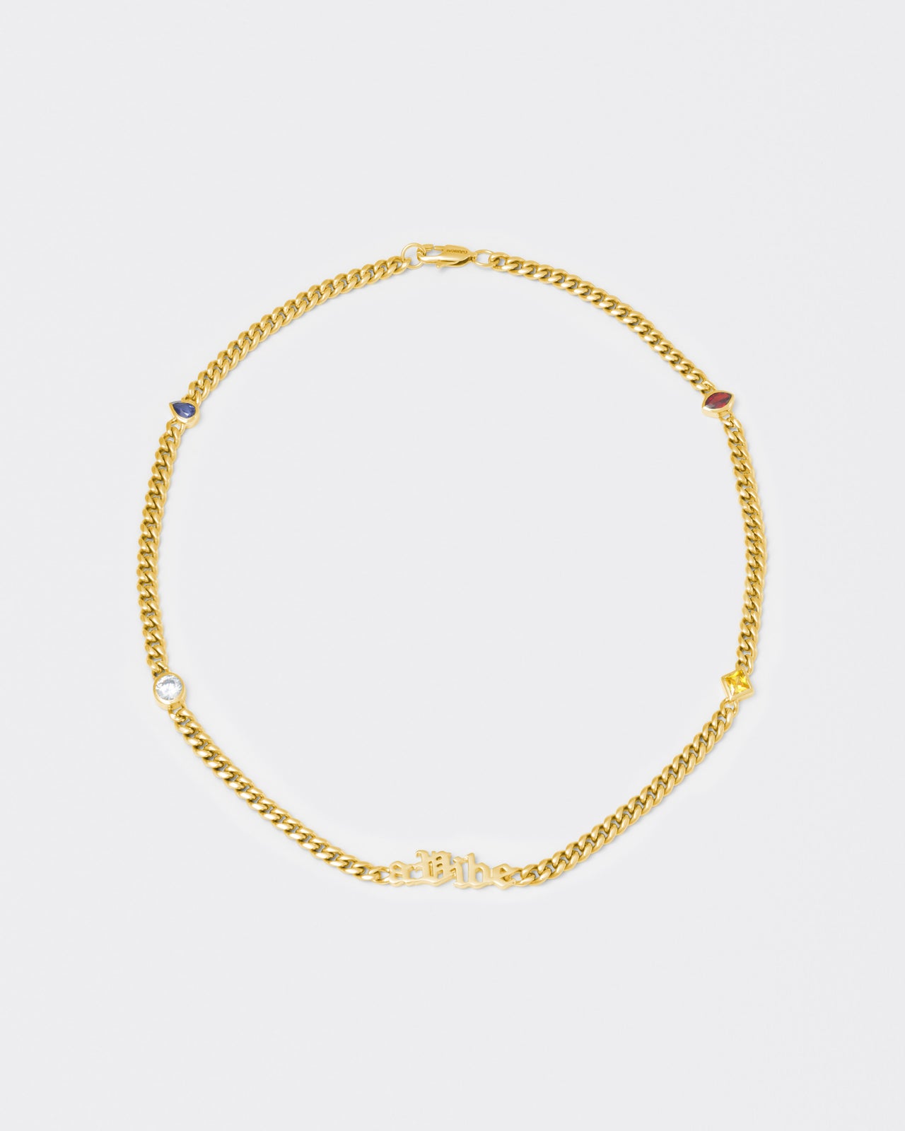 A Vibe cuban chain necklace with 18kt yellow gold coating, mixed shape bezel stones in diamond white, yellow, garnet, tanzanite and "A Vibe" central metal tag. Lobster clasp with logo