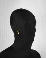 man with black suit wearing 18k yellow gold coated alien earrings with hand-set micropavé stones in white on white hand painted glow in the dark enamel mini aliens