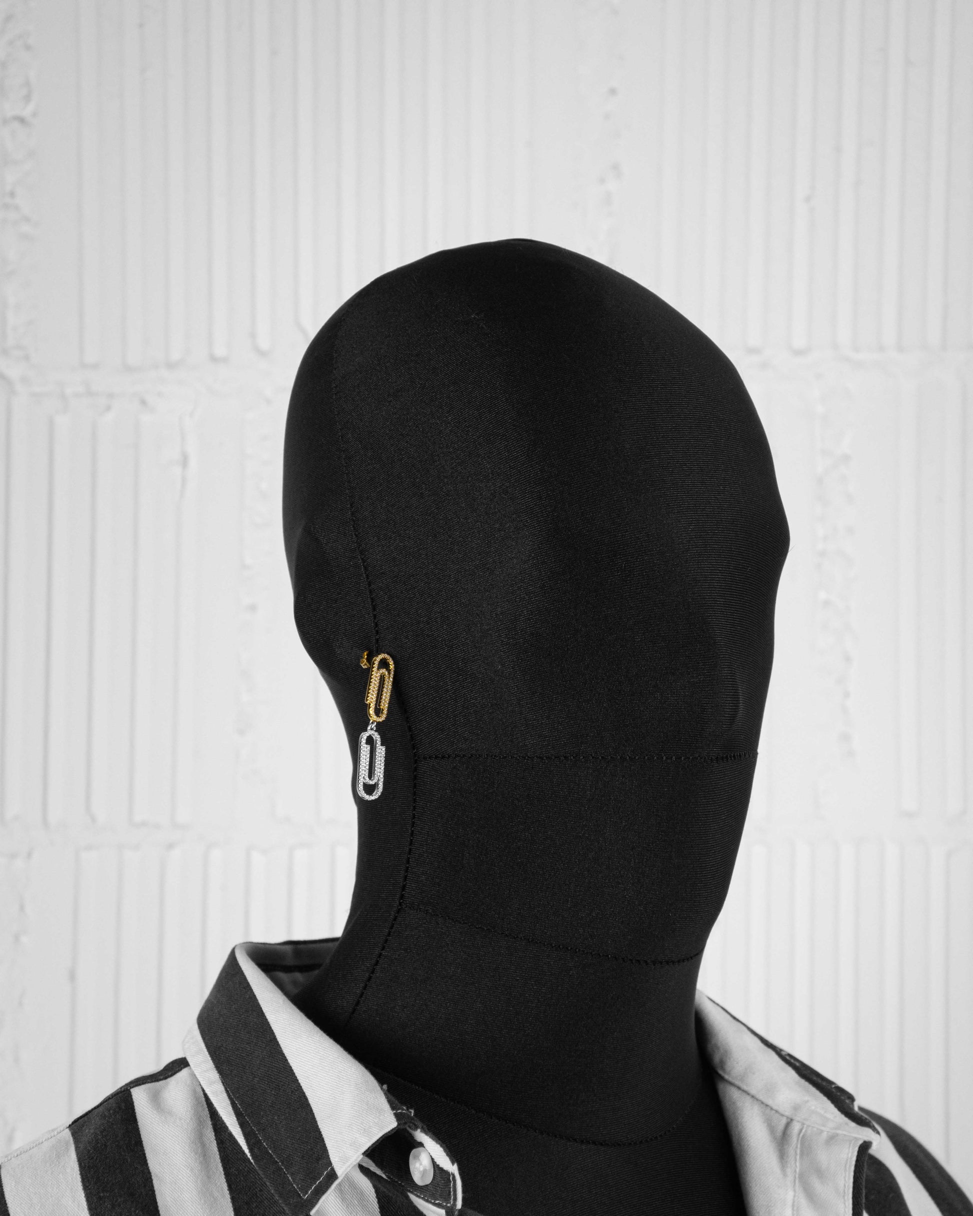 man with black suit wearing 18k yellow and white gold coated paperclip earrings with hand-set micropavé stones in white on constrasting asymmetrcial links