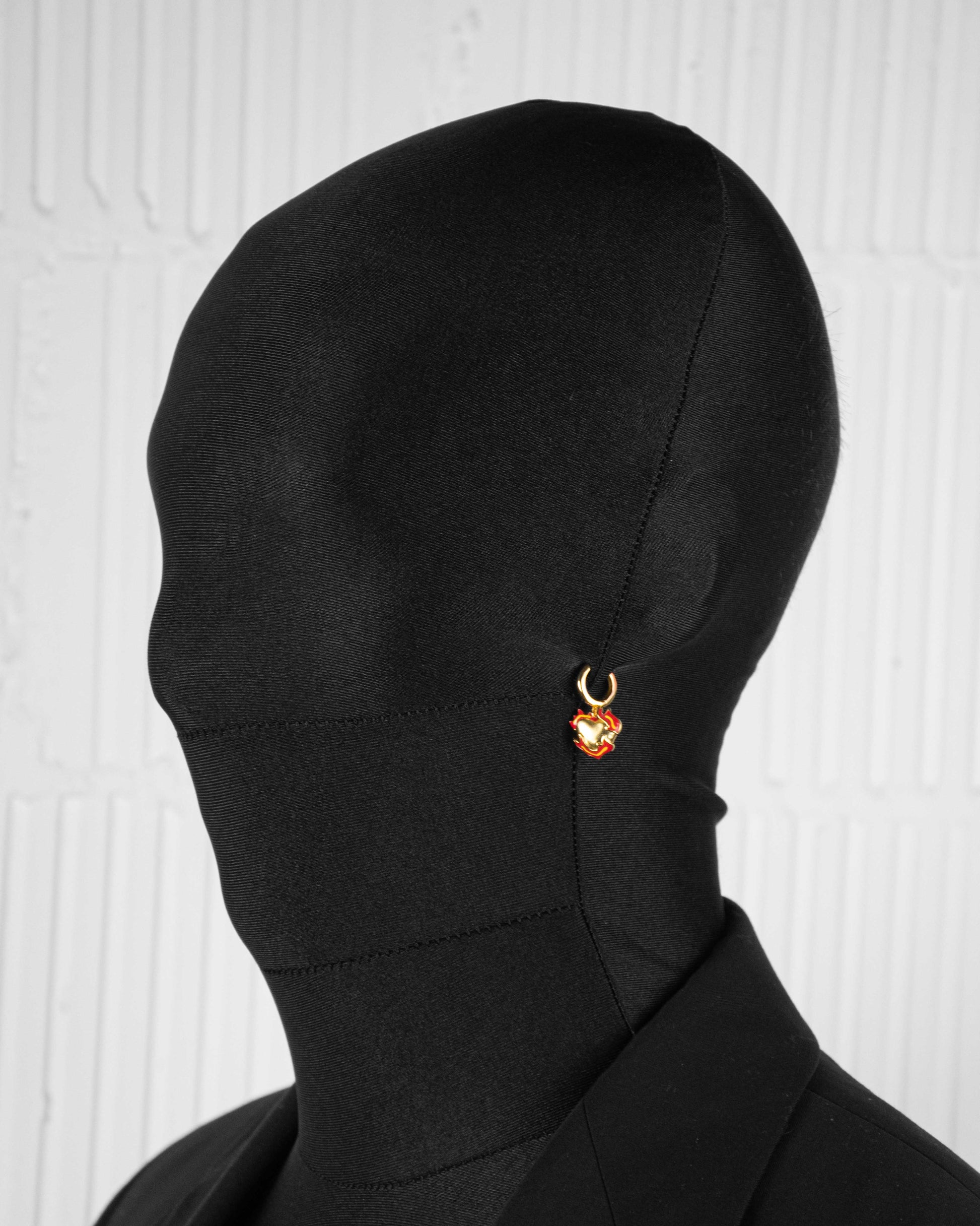man with black suit wearing 18k yellow gold coated heart earrings with red-yellow hand painted enamel and satined finishing