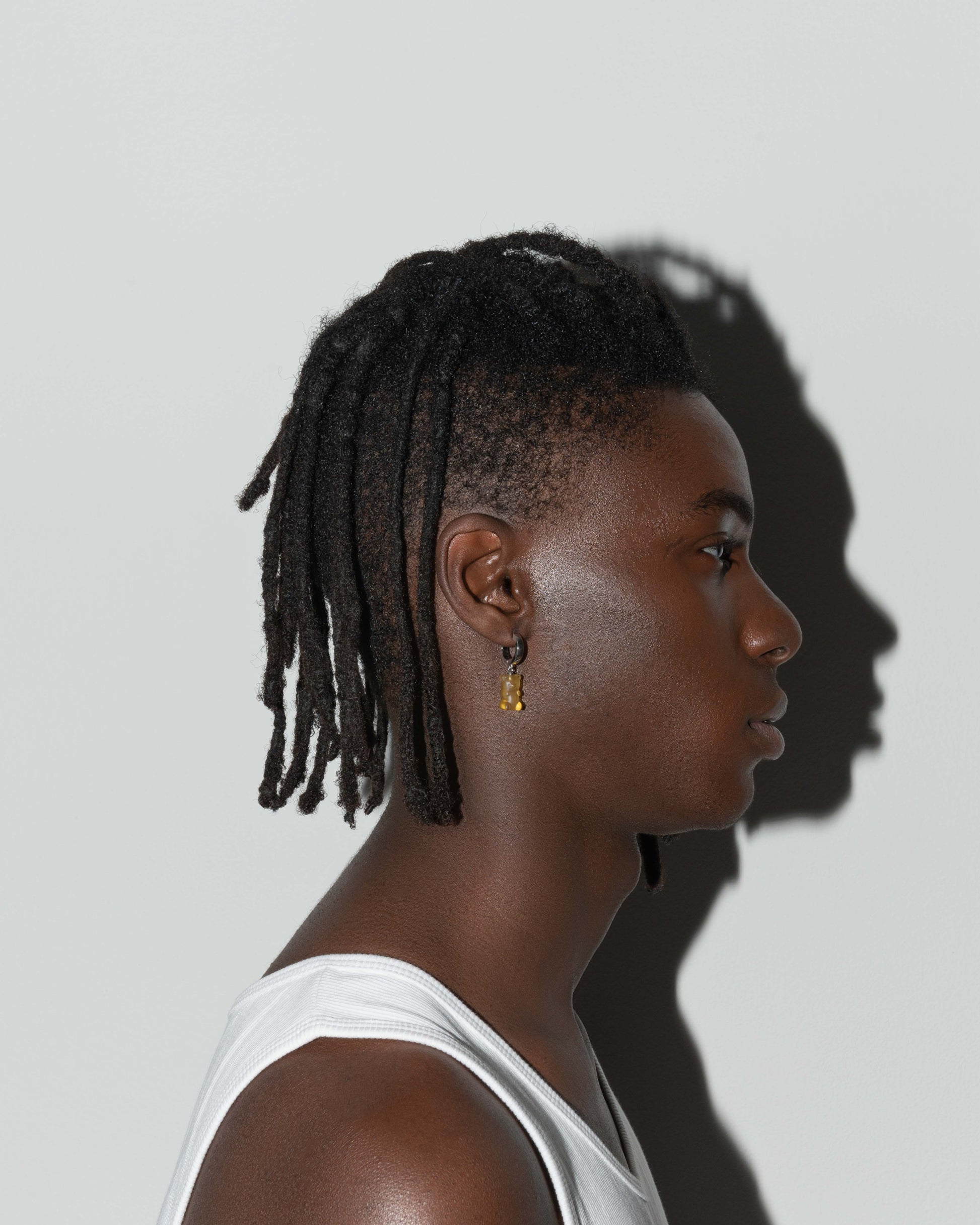 street style man wearing 18k white gold coated gummy bear mono earring with 3D cut sandblasted crystal in yellow