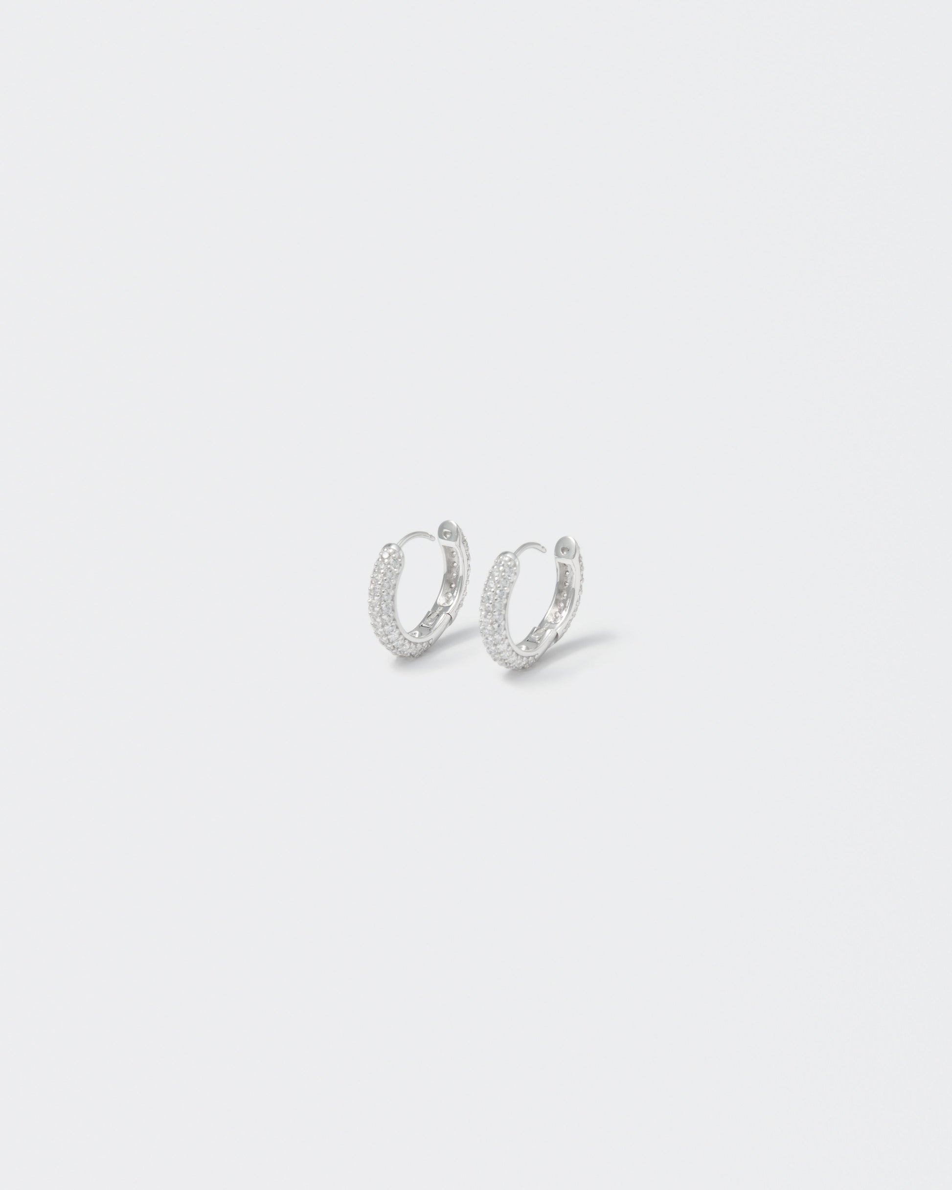 18k white gold coated hoop earrings with all around hand-set micropavé stones in white and lasered logo on the inside