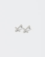 Reversed cross earrings with 18kt white gold coating with round brilliant-cut stones in diamond white. Silver 925 pin and butterfly closure with logo