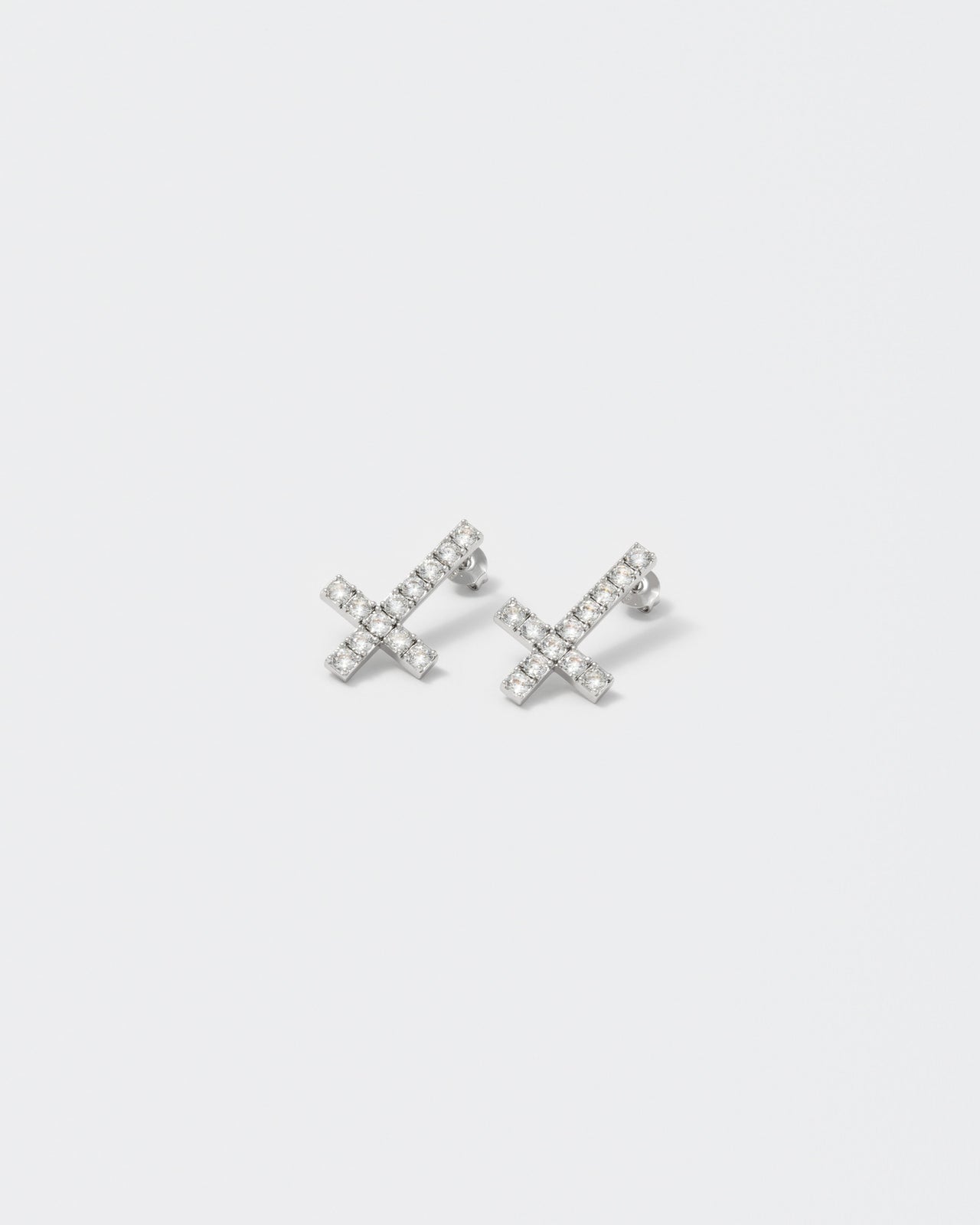 Reversed cross earrings with 18kt white gold coating with round brilliant-cut stones in diamond white. Silver 925 pin and butterfly closure with logo