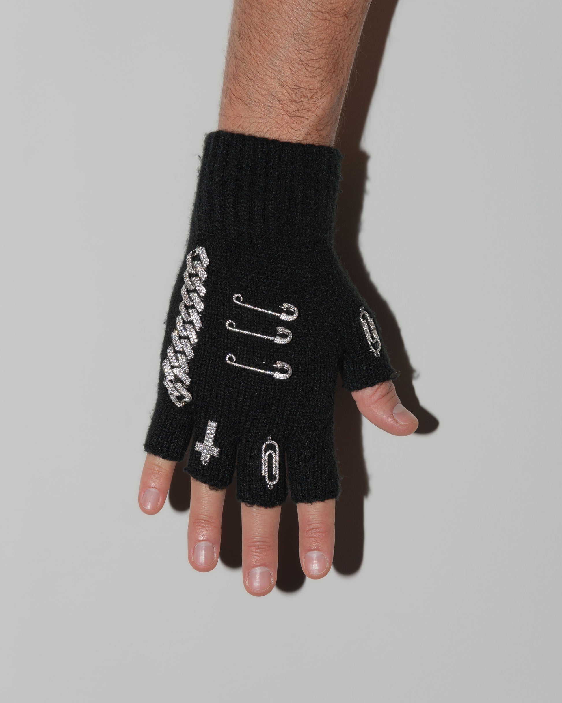 man wearing upcycled fingerless wool gloves in black with DARKAI jewelry hardware all over. Custom made pair designed for January 2024 Paris Fashion Week