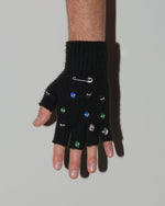 man wearing upcycled fingerless wool gloves in black with DARKAI jewelry hardware all over. Custom made pair designed for January 2024 Paris Fashion Week